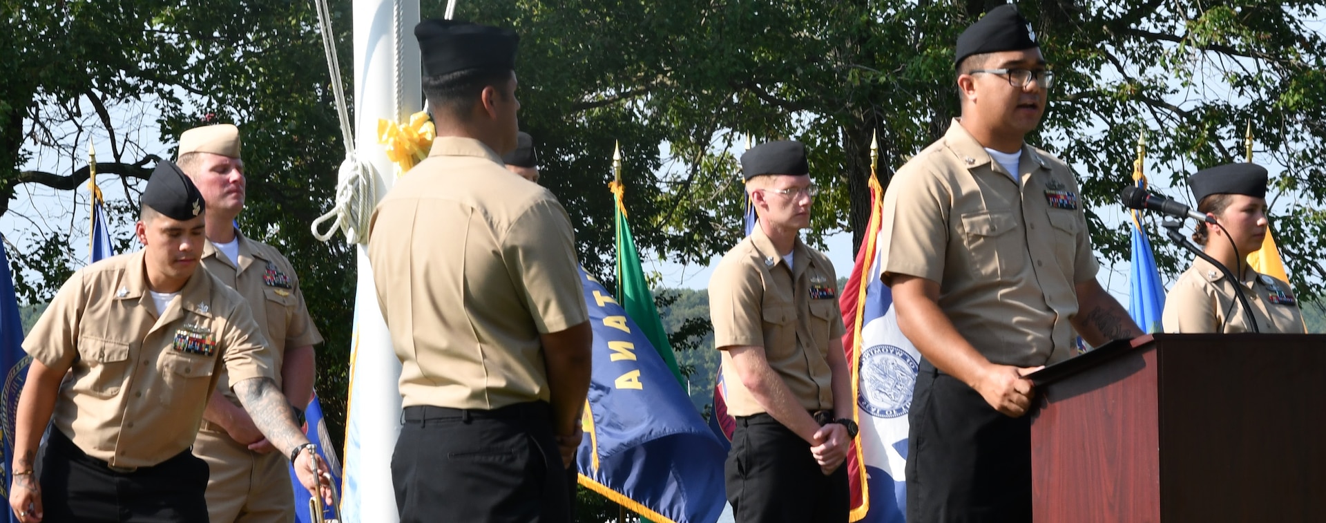 IMAGE: DAHLGREN. Va. (Sept. 11, 2019) – Navy chief select Elijah Chavira shares a story of heroism in response to the terrorist attacks and ensuing tragedies on 9/11. Chavira was one of seven chief select ‘heroism readers’ based at commands located on Naval Surface Facility Dahlgren who recounted acts of heroism on that tragic day in our nation’s history.

Chavira – reading to military, first responders, government and contractor personnel gathered to honor the victims of 9/11 – recounted that:
“With limited detail of what was happening and no time to do pre-flight checklists, two D.C. Air National Guard pilots quickly scrambled to intercept United 93 after two other planes had hit the World Trade Center. They were completely unarmed. In the days before Sept. 11, there were no armed aircraft standing guard in Washington, D.C., ready to scramble at the first sign of trouble. Col. Marc Sasseville and Lt. Heather Penney were prepared to give their lives for their country, and ram the airline off course.”