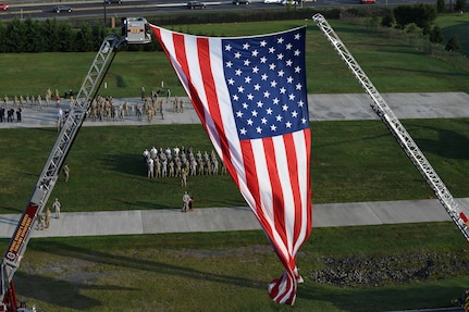 An American flag waves in the wind during the 9/11 memorial ceremony on Joint Base Andrews, Md., Sept. 11, 2019. The flag was draped between two fire truck ladders to honor the first responders who lost their lives after the 9/11 attacks in 2001. (U.S. Air Force photo by A1C Spencer J. Slocum)