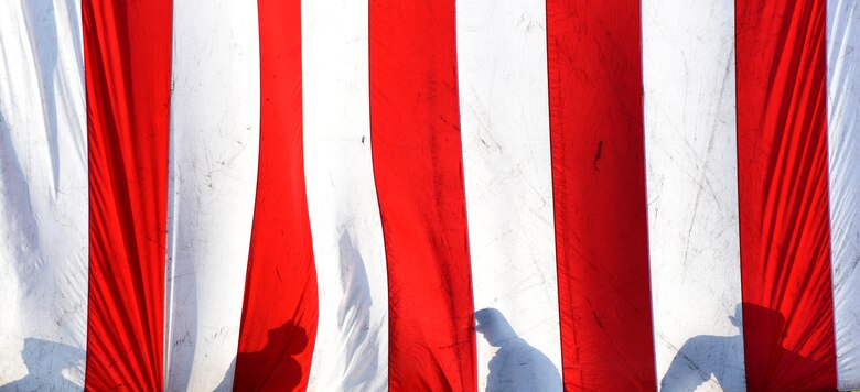 A group of Airmen hold the flag during the 9/11 memorial ceremony on Joint Base Andrews, Md. Sept. 11, 2019. Nearly 3,000 people lost their lives in the terrorist attack on Sept. 11, 2001. (U.S. Air Force photo by Airman 1st Class Noah Sudolcan)