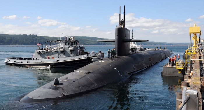 Tugs guide the Ohio-class ballistic missile submarine USS Louisiana (SSBN 743) to its berth at Naval Base Kitsap-Bangor after the completion of a patrol in 2012.