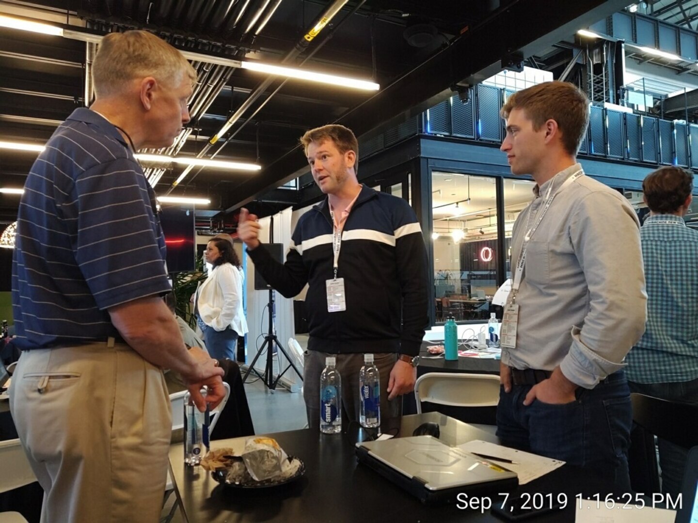 Bryan Kessel (right) and Nathan Desloover (center), both engineers at Naval Surface Warfare Center, Carderock Division, speak with Rear Adm. Lorin Selby, chief engineer and deputy commander for Ship Design, Integration and naval Engineering at NAVSEA, during the Hack the Machine 2019 in New York City on Sept. 7, 2019. (U.S. Navy photo by Garry Shields/Released)