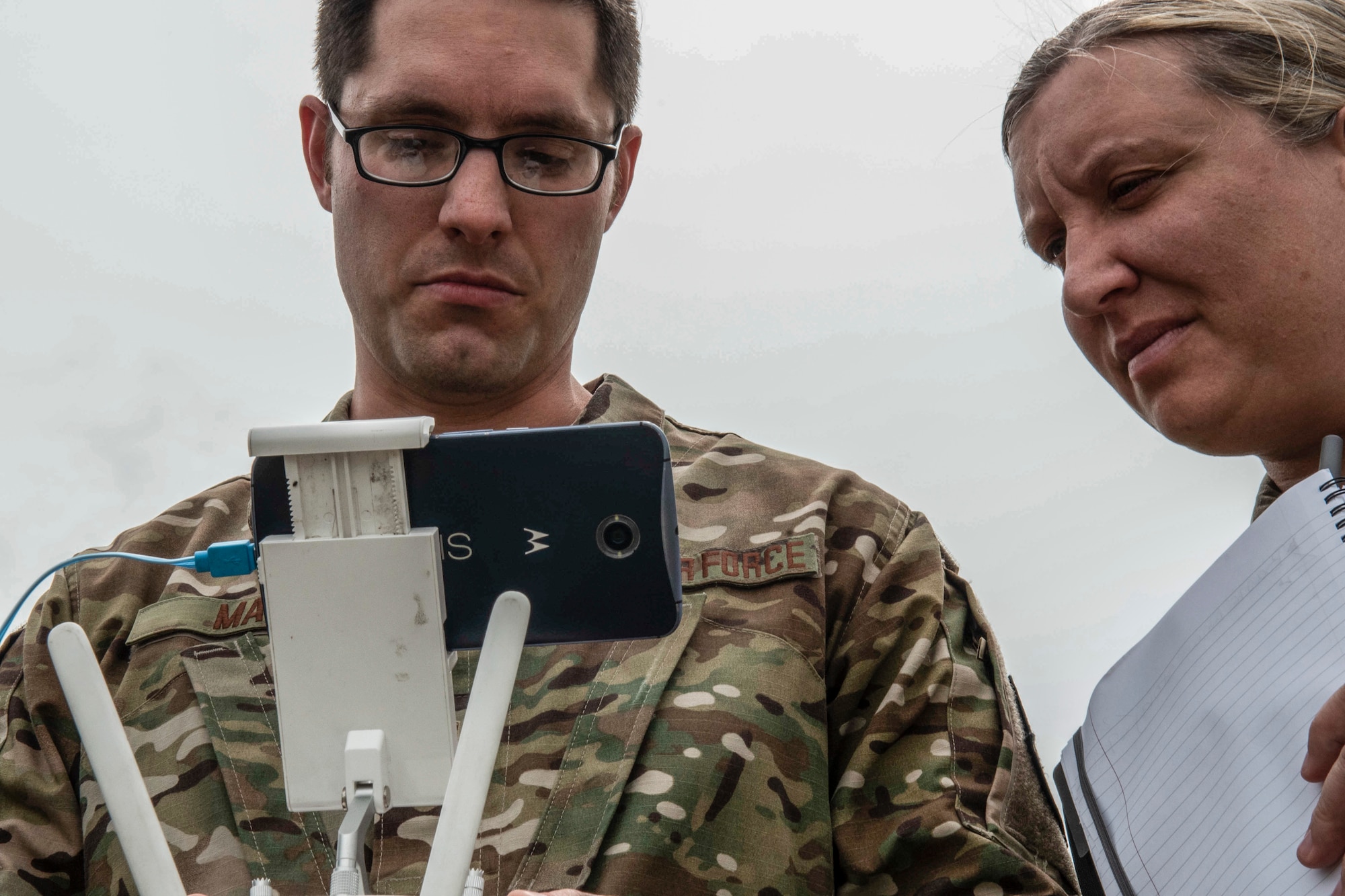 U.S. Air Force Master Sgt. Nathaniel May, 9th Intelligence Squadron operations superintendent, looks on the Hivemapper drone screen with Master Sgt. Ajenna Smith, 9th Security Forces Squadron innovations superintendent, at Beale Air Force Base, California,  April 12, 2019. The Hivemapper program is a three-dimensional drone asset can map infrastructure, while providing visualization and analytic tools. (U.S. Air Force photo by Tech. Sgt. Veronica Montes)