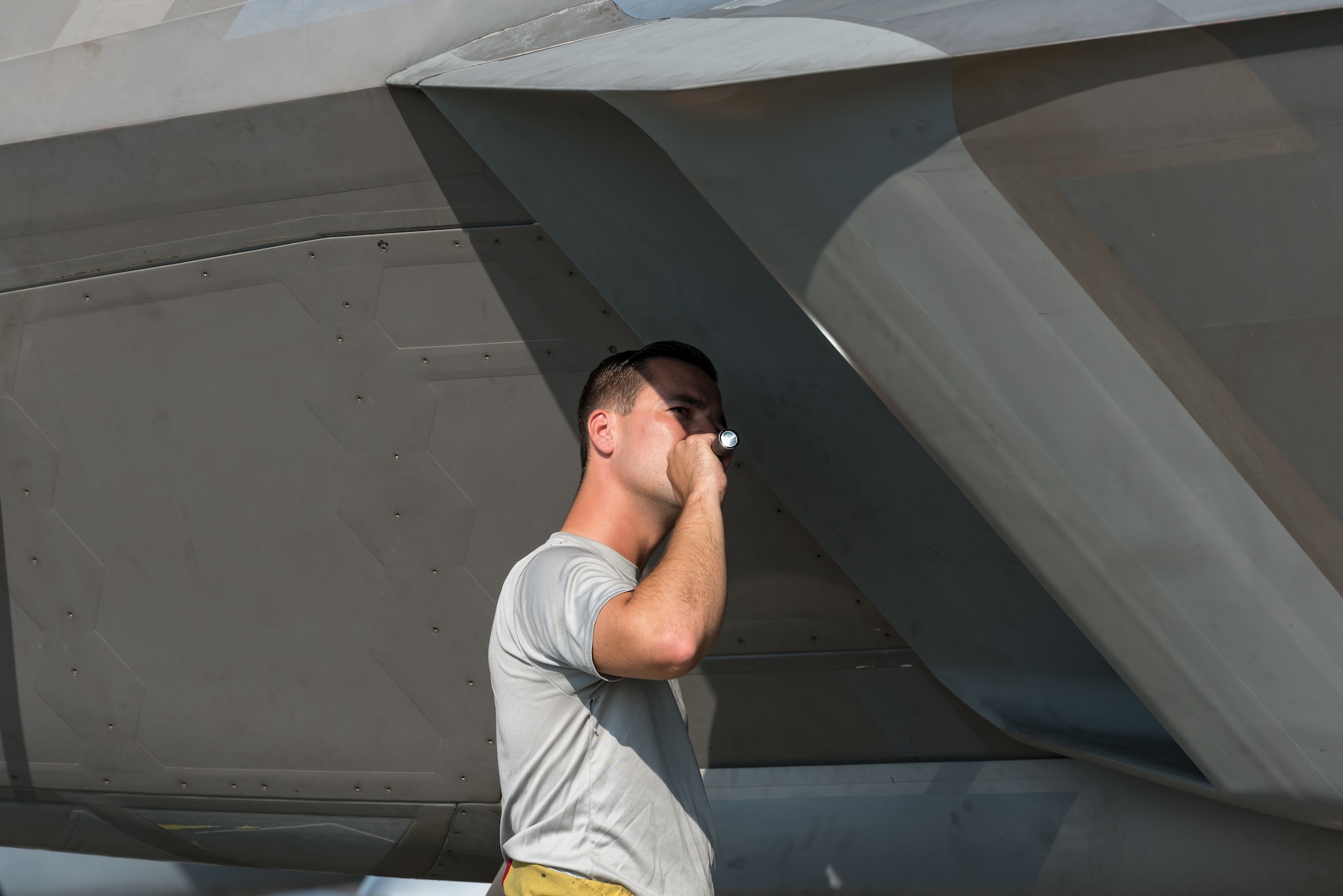 Staff Sgt. Zach Zistl, F-22 Raptor dedicated crew chief, inspects the engine intake Sept. 12, 2019, at Dover Air Force Base, Del. Zistl is a  member of the F-22 demonstration team from Joint Base Langley-Eustis, Va., that is scheduled to perform at the Thunder Over Dover 2019 open house and air show. (U.S. Air Force photo by Roland Balik)