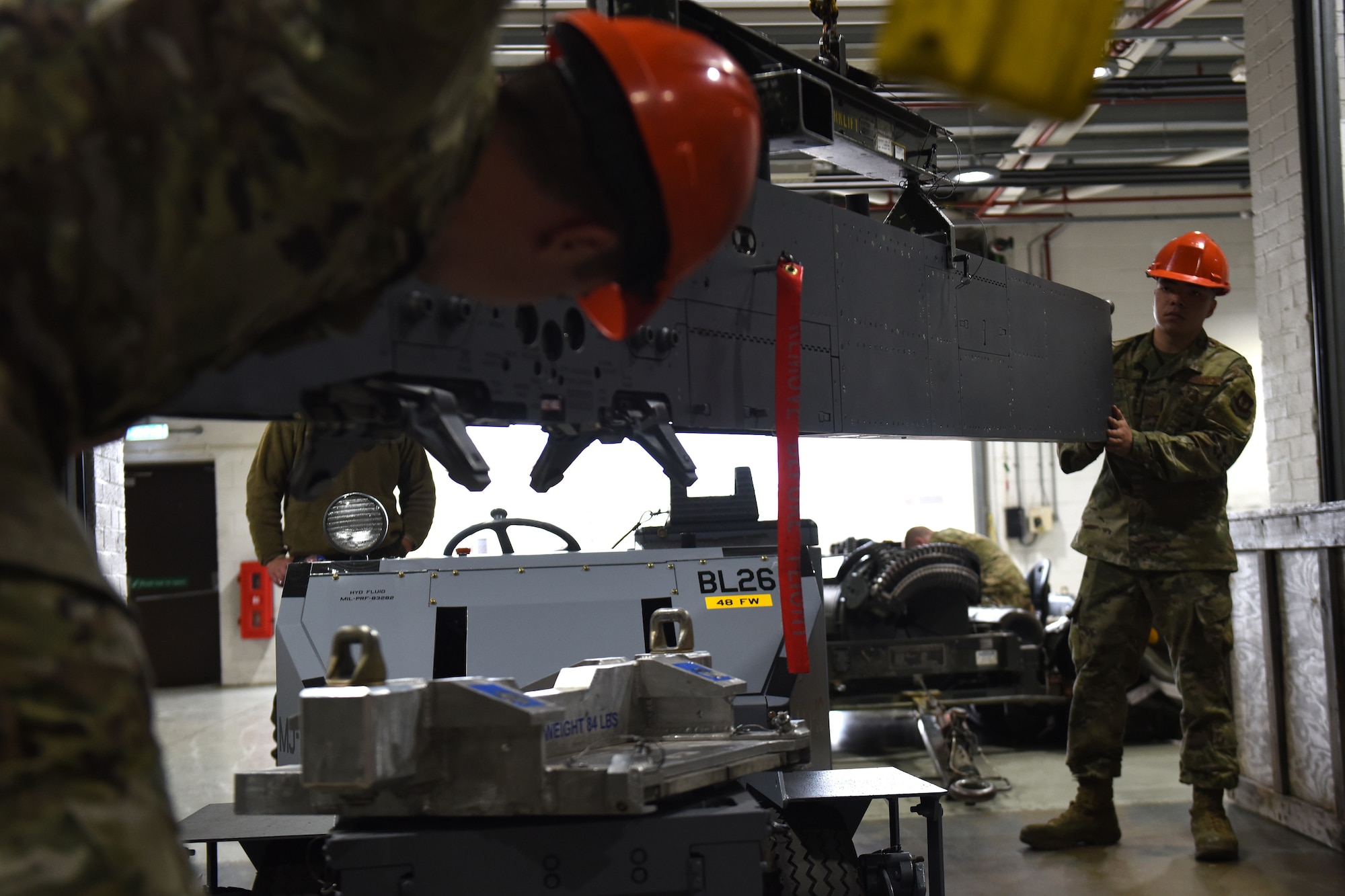 Armament maintenance technicians from the 48th Munitions Squadron use a crane to pick up a centerline pylon at Royal Air Force Lakenheath, England, Sept. 11, 2019. Armament flight Airmen are trained in complete disassemble, inspection, lubrication, reassembly, and functional checks for all weapons-related equipment from both the 48th Fighter Wing F-15C Eagle and F-15E Strike Eagles. (U.S. Air Force photo by Airman 1st Class Madeline Herzog)