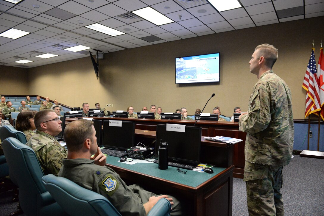 Members of Air Forces Northern update senior leadership in a conference room about Hurricane Dorian.