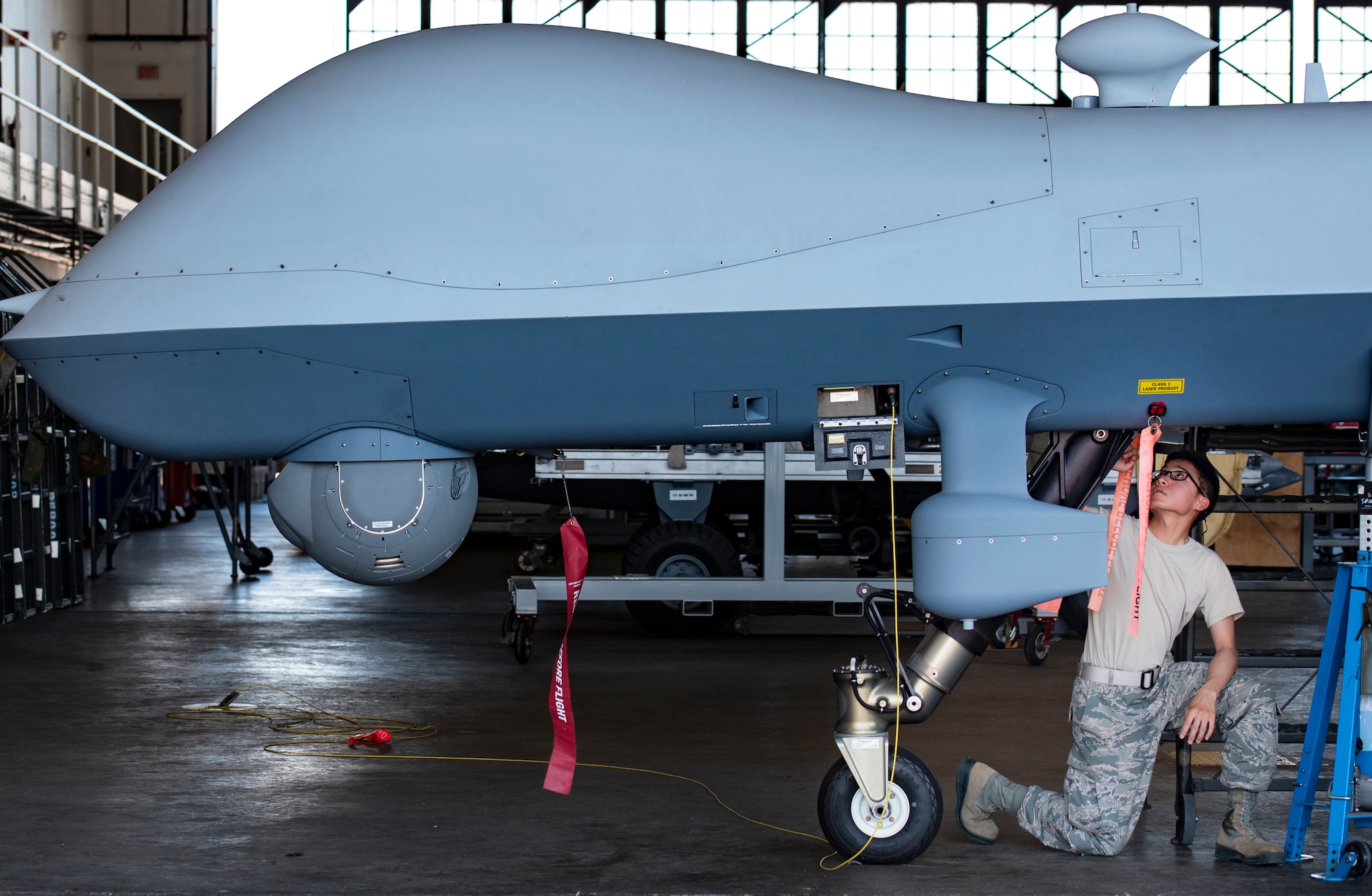 Airman 1st Class Obed Castro, 362nd Training Squadron MQ-9 crew chief apprentice course student, inspects an MQ-9 Reaper's nose landing gear at Sheppard Air Force Base, Texas, Sept. 9, 2019. Castro is performing a combined basic pre-flight and post-flight inspection. It is important for Airmen to be extremely meticulous when performing inspections so to prevent accidents and damage to the aircraft. A detail-oriented eye is trained through patience and repetition. (U.S. Air Force photo by Airman 1st Class Pedro Tenorio)