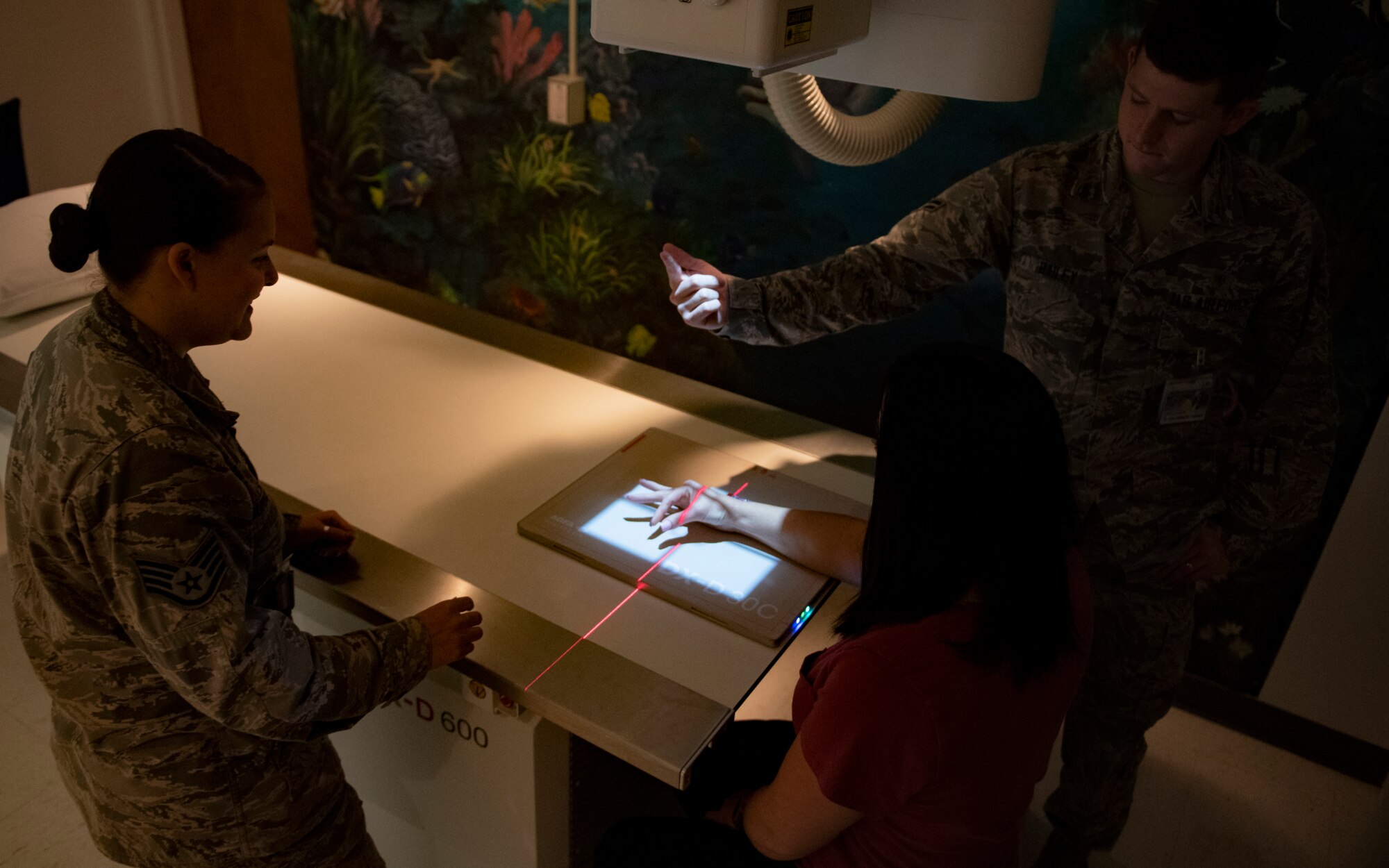 From left, Staff Sgt. Morgan Burkett, diagnostic imaging Phase II student, Brook Hutson, 82nd Medical Support Squadron registered diagnostic medical sonographer, and Airman Koby Bailey, 82nd MDSS radiology technologist (r), perform a hand x-ray at Sheppard Air Force Base, Texas, Sept. 12, 2019. Burkett is a phase II student who has just arrived from Fort Sam Houston, TX, which is where diagnostic imaging Airmen start their training. Bailey and Hutson are instructors that help with her clinical training which will upgrade Burkett to a three level. Burkett works in the clinic during the day and, along with her other phase II classmates training here, goes to class in the afternoon. (U.S. Air Force photo by Airman 1st Class Pedro Tenorio)