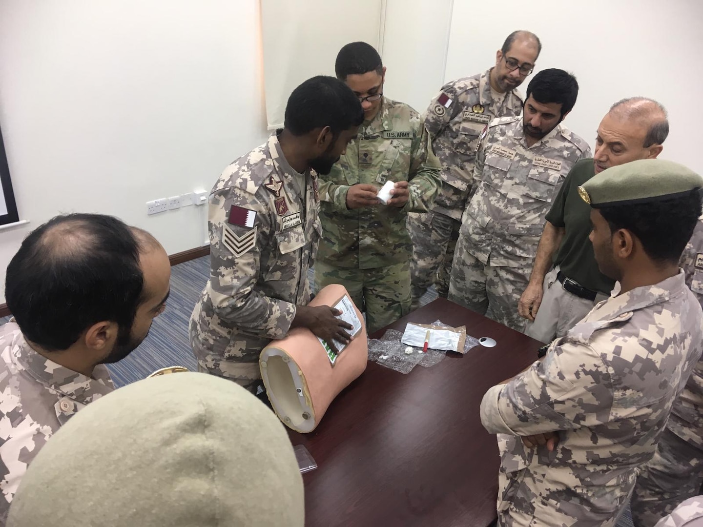 A New Jersey Army National Guard Soldier discusses a Tactical Combat Casualty Care (TCCC) scenario with members of the Qatari Emiri Land Forces (QELF) Sept. 8 -12, 2019, at the Qatar Emiri Land Force Artillery School in Al Rayyan Municipality, Qatar.