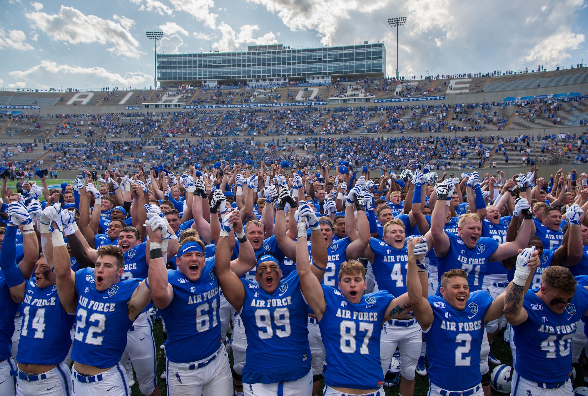 U.S. Air Force Academy football players raise their hands in victory