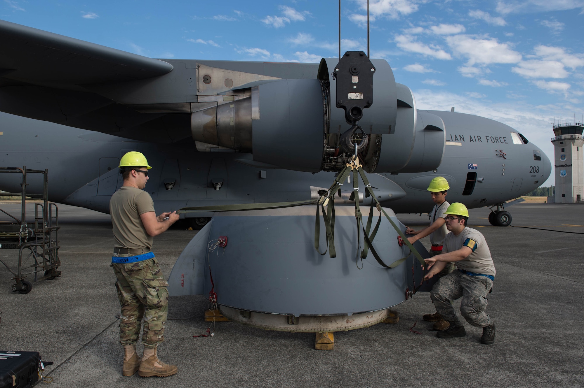 Senior Airman Matt Summers, Airman 1st Class Placido Solis and Senior Airman Justin Muniz, 62nd Maintenance Squadron, left to right, work to move a cracked engine ring cowl from a Royal Australian Air Force C-17 Globemaster III at Joint Base Lewis-McChord, Sept. 5, 2019.