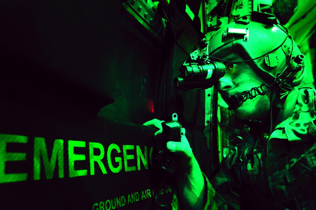 U.S. Air Force Senior Airman Larry Webster, a loadmaster with the 774th Expeditionary Airlift Squadron, scans for threats using night vision goggles aboard a C-130H Hercules aircraft after completing a cargo airdrop mission over Ghazni province, Afghanistan, Oct. 7, 2013. (DoD photo by Master Sgt. Ben Bloker, U.S. Air Force/Released)