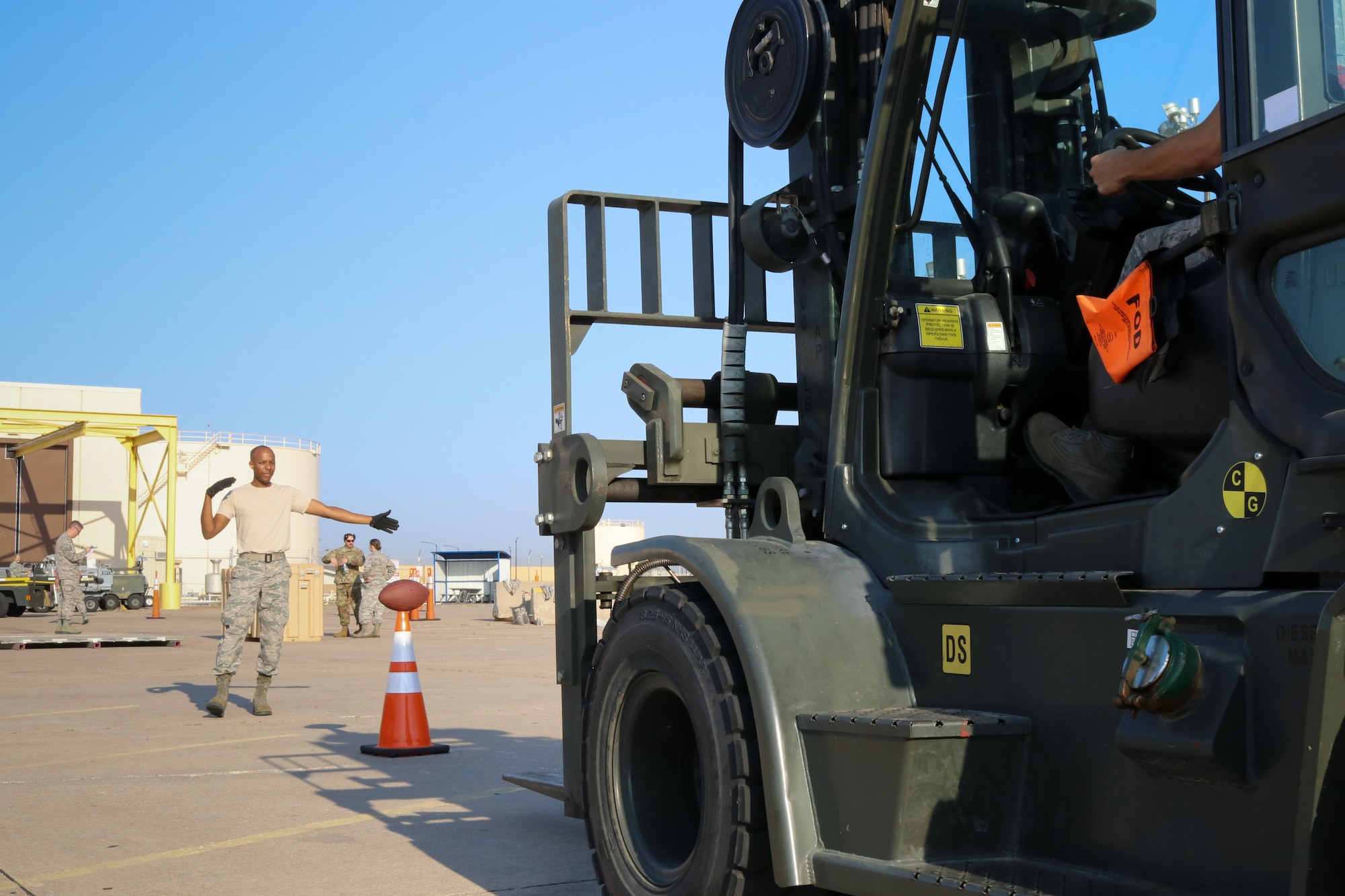Senior Airman Samuel Lee, 72nd Aerial Port Squadron aerial transportation specialist, directs a forklifft during a rodeo, Sept. 6, 2019, at Tinker Air Force Base, Oklahoma. The rodeo incorporated various jobs competed by aerial port in a fun and competitive atmosphere. (U.S. Air Force photo by Senior Airman Mary Begy)