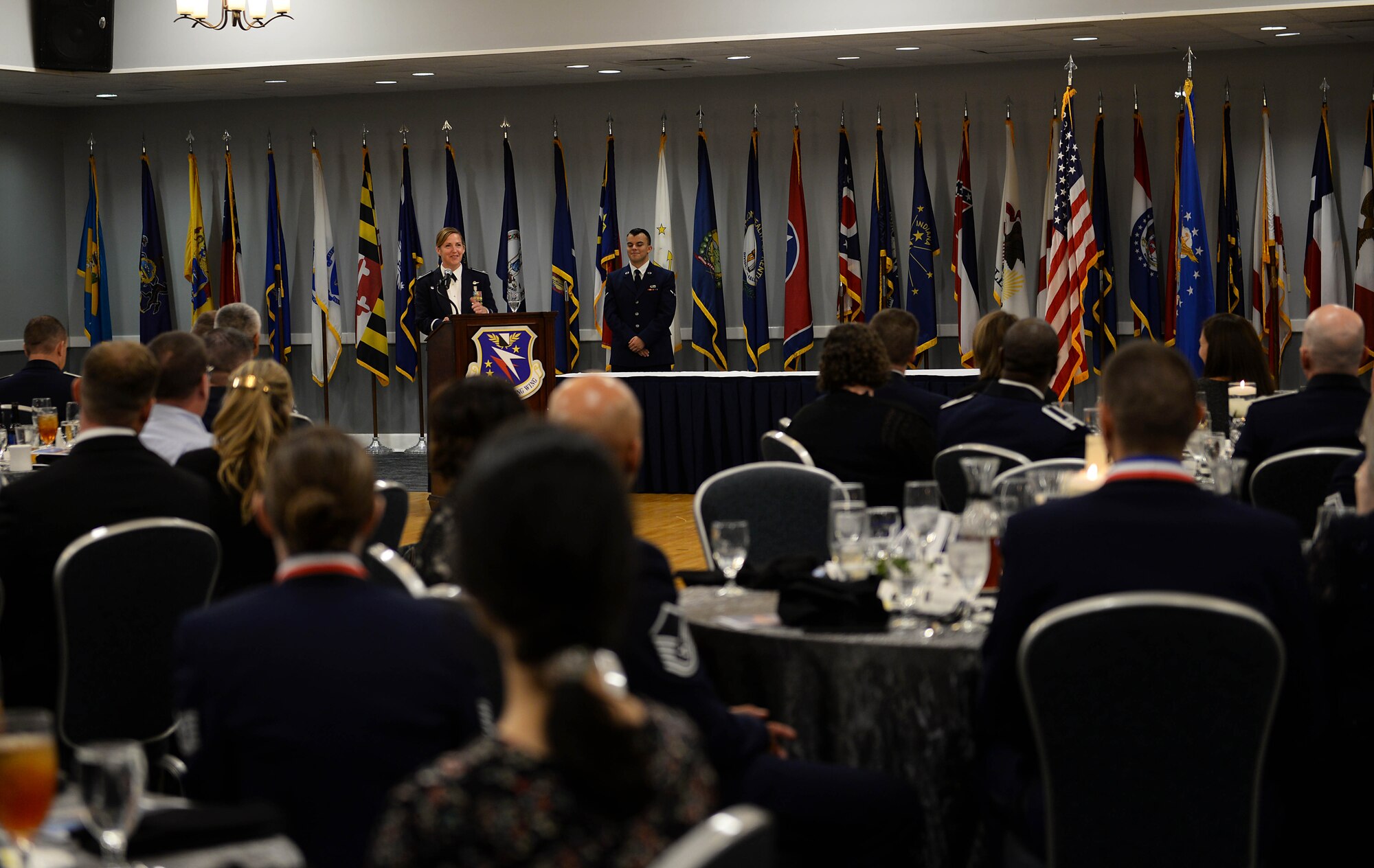 Col. Samantha Weeks, 14th Flying Training Wing commander, speaks to attendees during a Senior NCO Induction Ceremony Sept. 9, 2019, at the Club on Columbus Air Force Base, Miss. Toward the end of the ceremony Weeks thanked all those who coordinated the event, those who attended and reminded the inductees to look around the room and take in those who support them and attended this ceremony recognizing their achievement.  (U.S. Air Force photo by Airman 1st Class Hannah Bean)