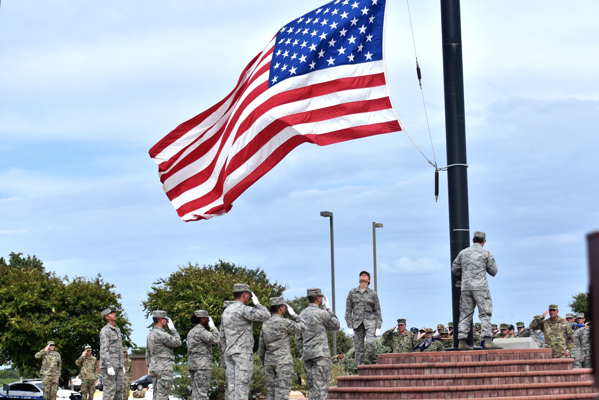 Members of the Goodfellow Honor Guard lower the wing flag during a special retreat ceremony outside of the Norma Brown building on Goodfellow Air Force Base, Texas, Sept. 11, 2019. The retreat ceremony was held to honor those who gave the ultimate sacrifice during the events of 9/11. (U.S. Air Force photo by Senior Airman Seraiah Wolf/Released)