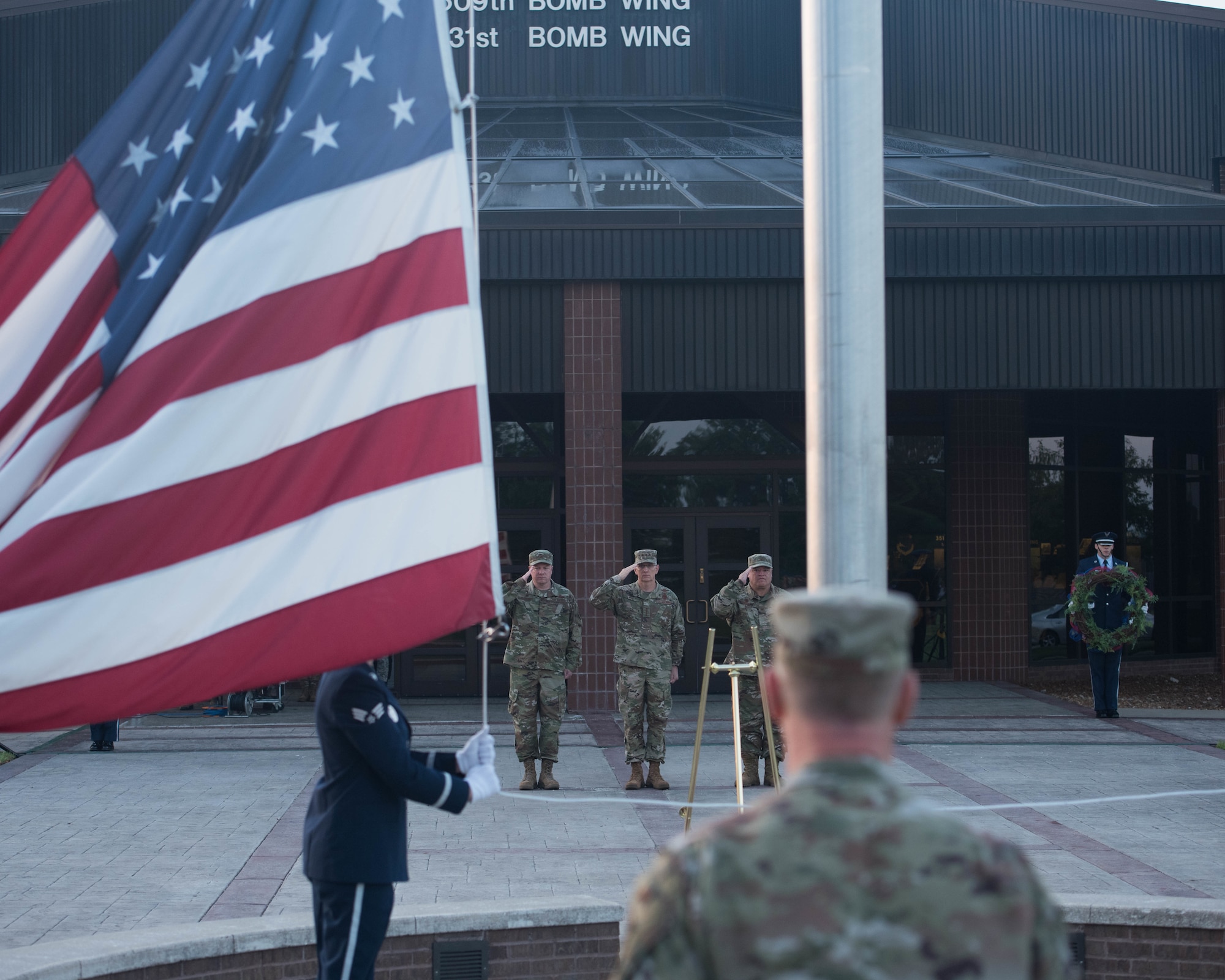 Gen. Tim Ray, Commander, Air Force Global Strike Command (Center) accompanied by Col. Jeffrey Schreiner, Commander, 509th Bomb Wing (Left) and Col. Ken Eaves, Commander, 131st Bomb Wing (Right) salute the Flag during a 9/11 Remembrance Ceremony at Whiteman Air Force Base, Missouri, Sep.11 2019.  Whiteman AFB Base Honor Guard raises the flag to half staff.  (U.S. Air Force Photo by Senior Airman Ashley Adkins)