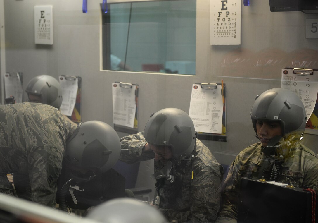 An Airman performs a chamber reaction during a simulated chamber flight Sept. 3, 2019, inside the Hyperbaric Chamber Room on Columbus Air Force Base, Miss. To give a more accurate representation of the exercise, volunteers were asked to participate as students inside the chamber, providing a level of unpredictability for the AOP Airmen to critically think rather than predicting what to do. (U.S. Air Force photo by Airman 1st Class Hannah Bean)