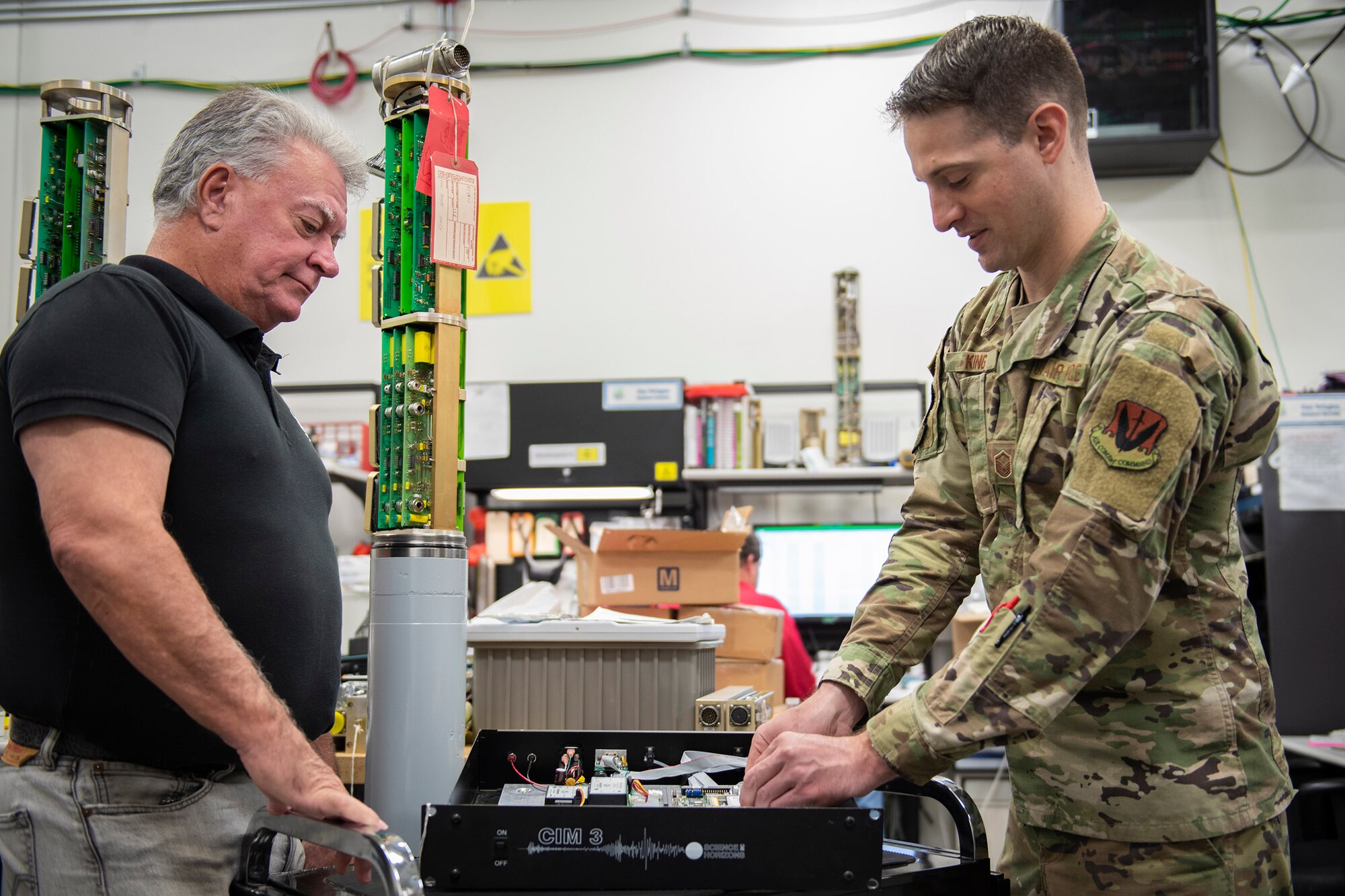 Doug Dale (left), 709th Support Squadron flight chief, and Master Sgt. Joseph King, 709th SPTS Central Repair Facility superintendent, work on a device that converts and combines multi-serial signals into a single data stream for the Air Force Technical Applications Center, Patrick AFB, Fla.  Dale and his team developed a solution to dramatically increase AFTAC's Geophysical Field System sparing posture worldwide.  (U.S. Air Force photo by Matthew S. Jurgens)
