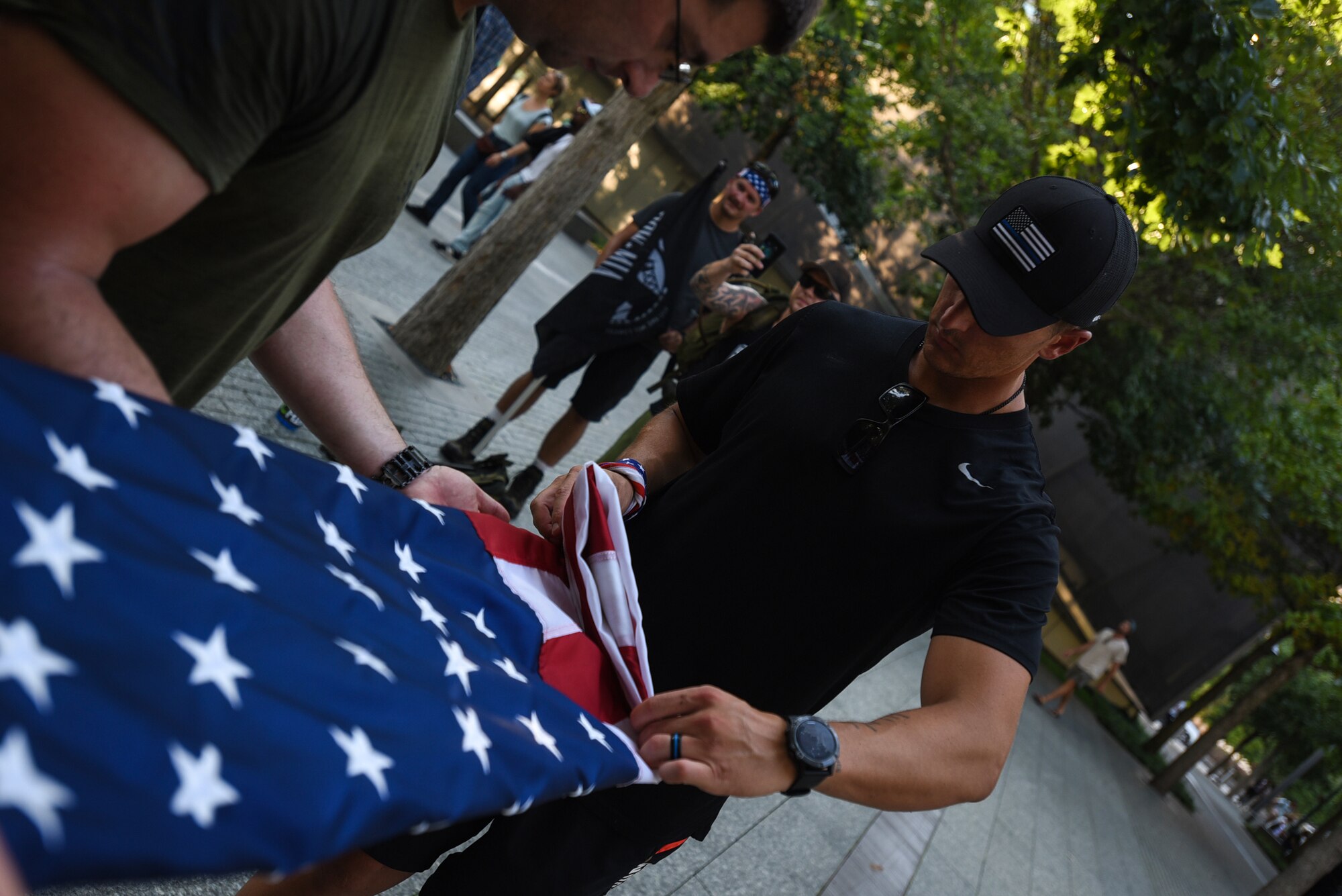 U.S. Air Force Master Sgt. Jason Vavro, 818th Mobility Support Advisory air advisor, folds the American flag after the 100 mile ruck march in honor of Sept. 11 in New York City Sept. 11, 2019. After arriving, the American flag was folded during a ceremonial display and then presented to a staff member of the memorial who will display it within the museum. (U.S. Air Force photo by Airman 1st Class Ariel Owings)