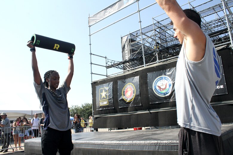 U.S. Navy Petty Officer Mikala Hawkins finishes up her last few burpees while U.S. Air Force 2nd Lt. Brett Spongberg cheers her on during the 2019 Alpha Warrior Inter-Service Battle Sept. 14, 2019, at Retama Park, Selma, Texas. Spongberg and his five Air Force teammates won the competition against the Navy and U.S. Army. (U.S. Air Force photo by Debbie Aragon)