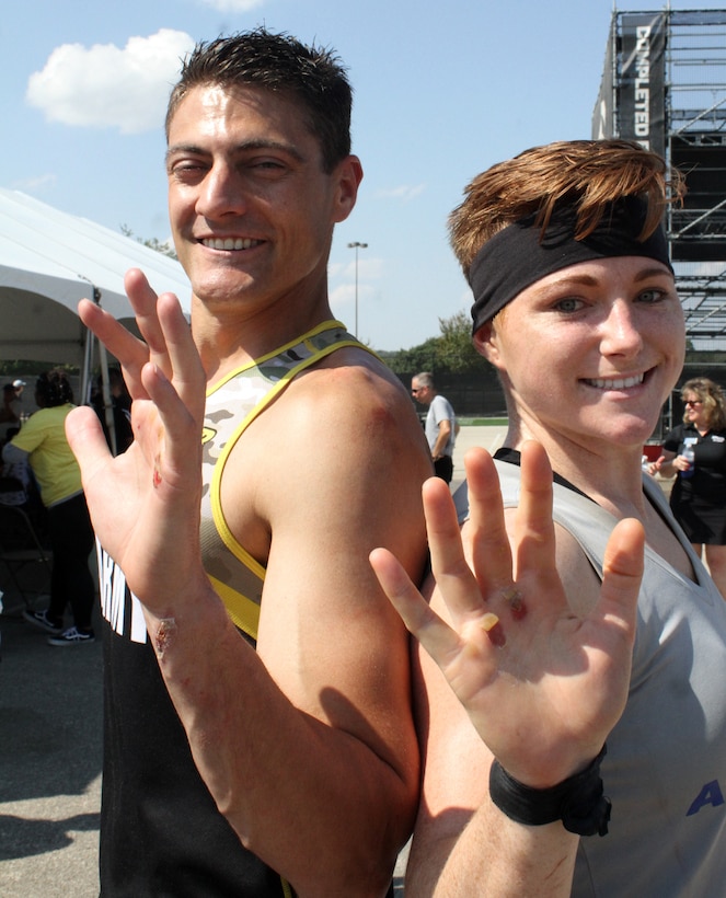 U.S. Army Lt. Col. Eric Palicia and U.S. Air Force 2nd Lt. Michelle Strickland display their wounds after leaving it all on the course during the 2019 Alpha Warrior Inter-Service Battle Sept. 14, 2019, at Retama Park, Selma, Texas. Strickland, who had the fastest time of all females on the course, and her five Air Force teammates won the competition for the second year in a row. The Army came in second followed by the U.S. Navy. (U.S. Air Force photo by Debbie Aragon)