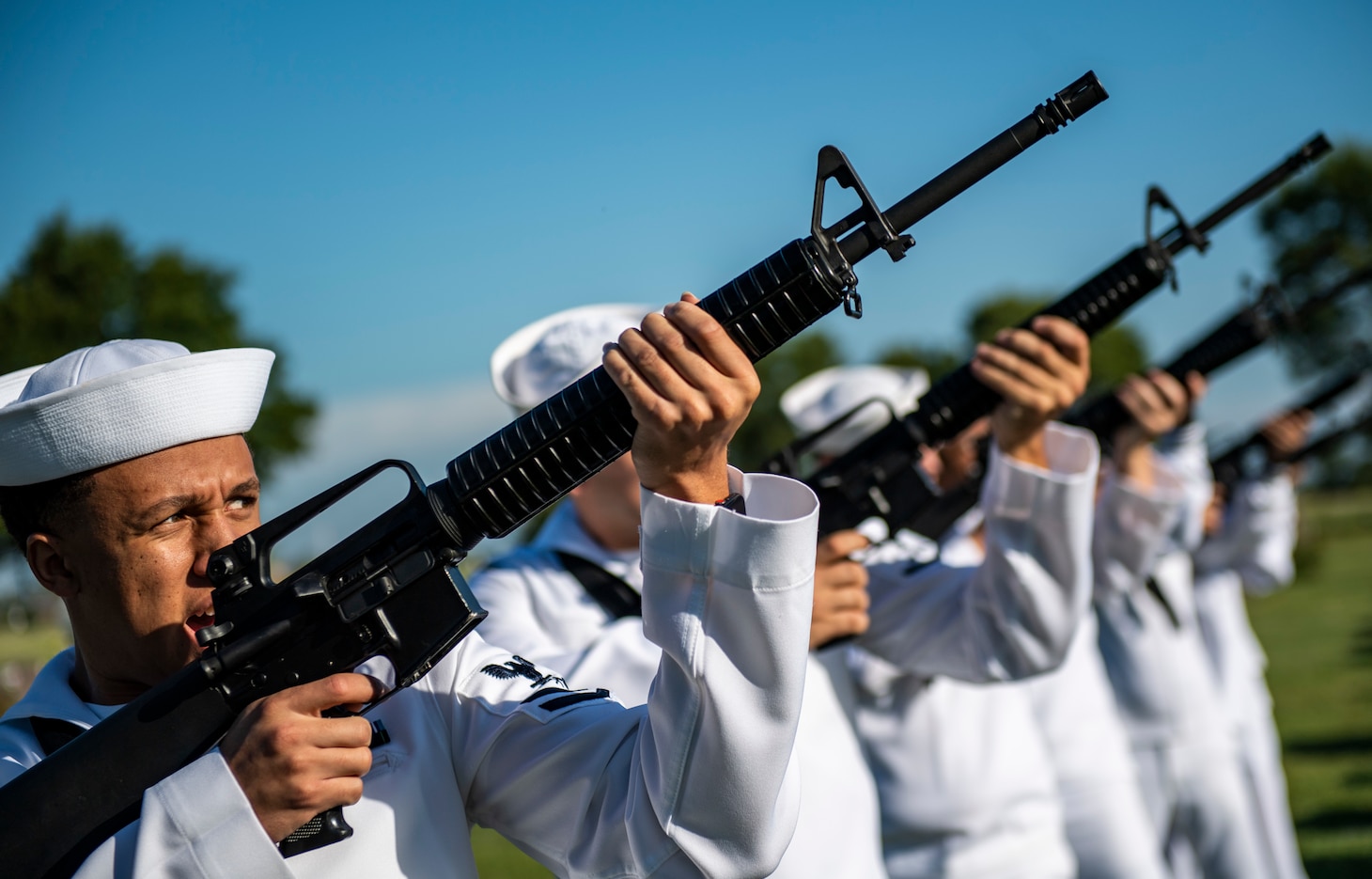 Sailors render a gun salute.