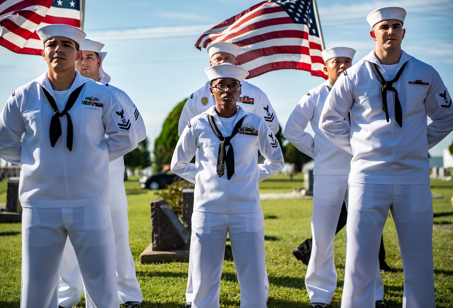 Sailors stand at parade rest.