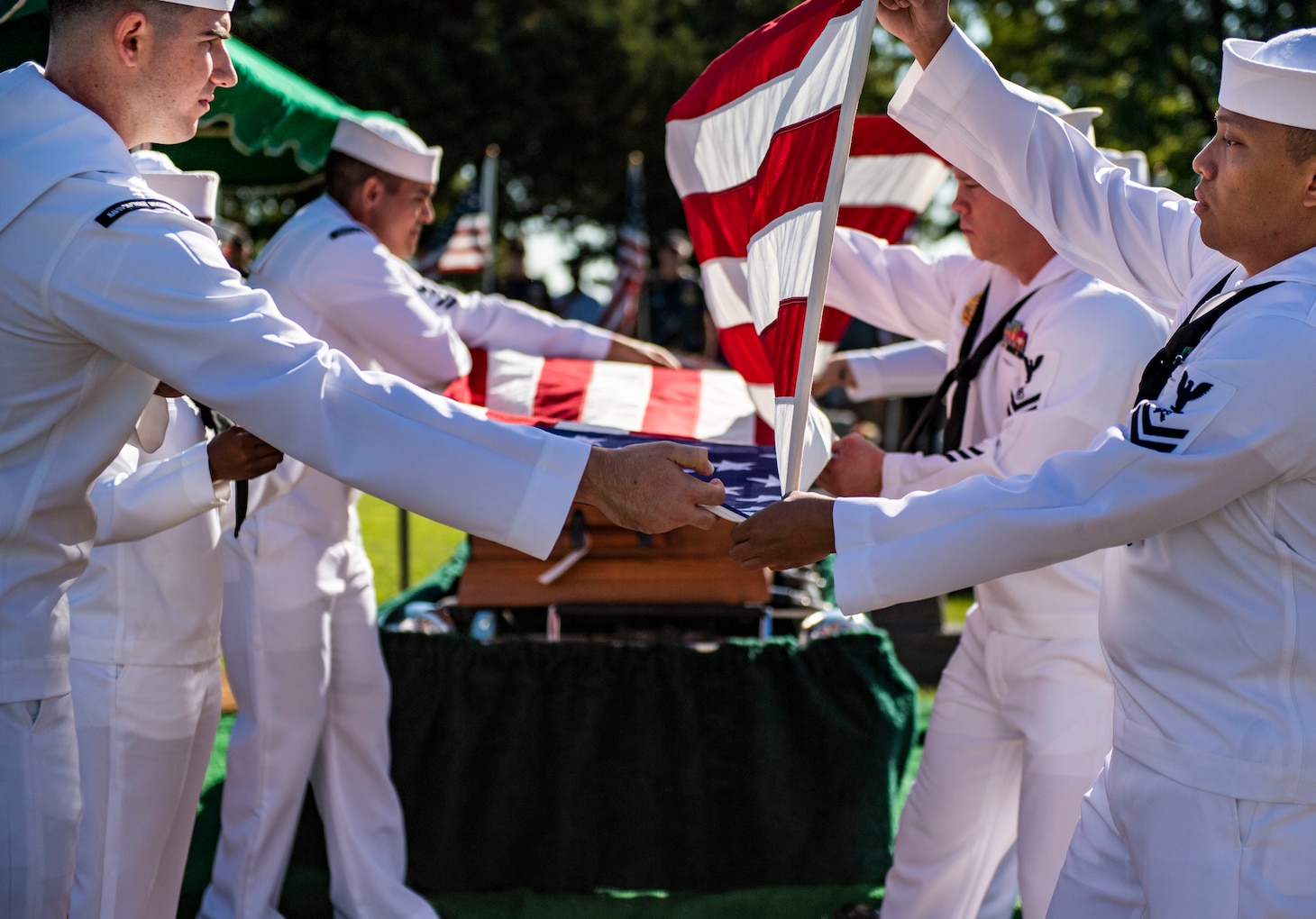 Sailors fold a flag