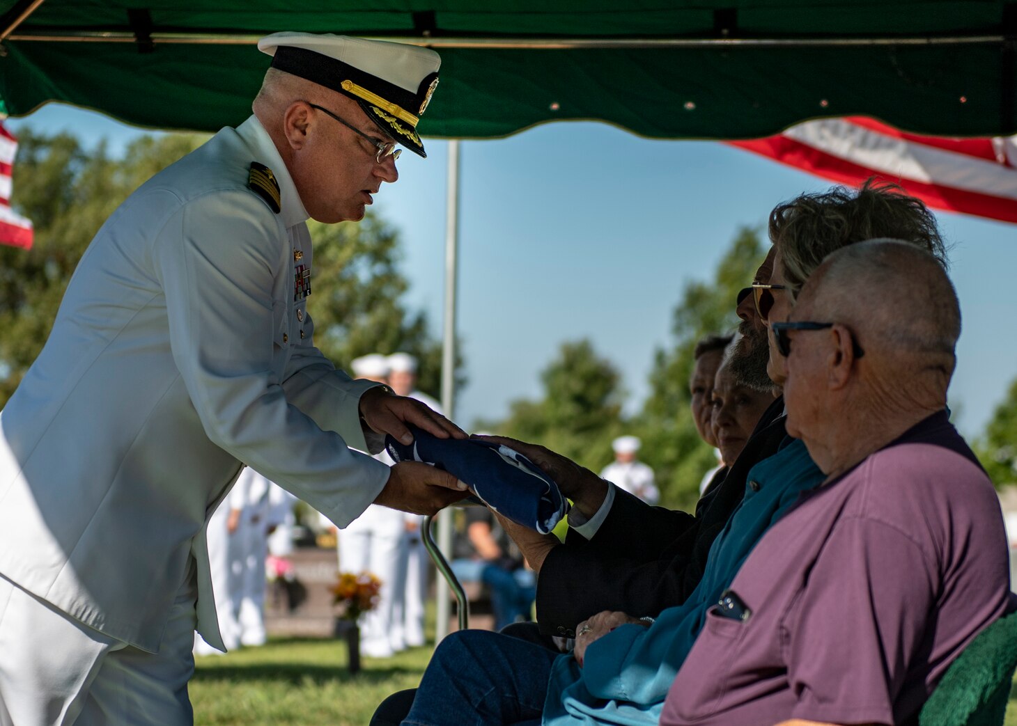 A sailor presents a flag to the next of kin.