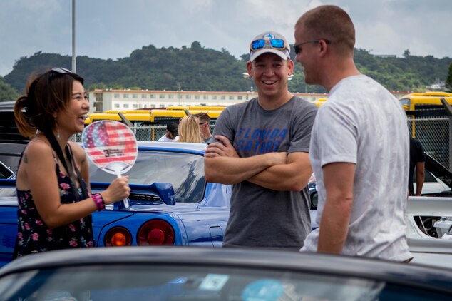 Car enthusiasts from the local and U.S. communities share conversation during the 2nd annual United Service Organizations Okinawa car show on Camp Foster, Okinawa, Japan, September 14, 2019. The car show helped strengthen relationships between local residents and members of the U.S. community through a public automobile exhibition.