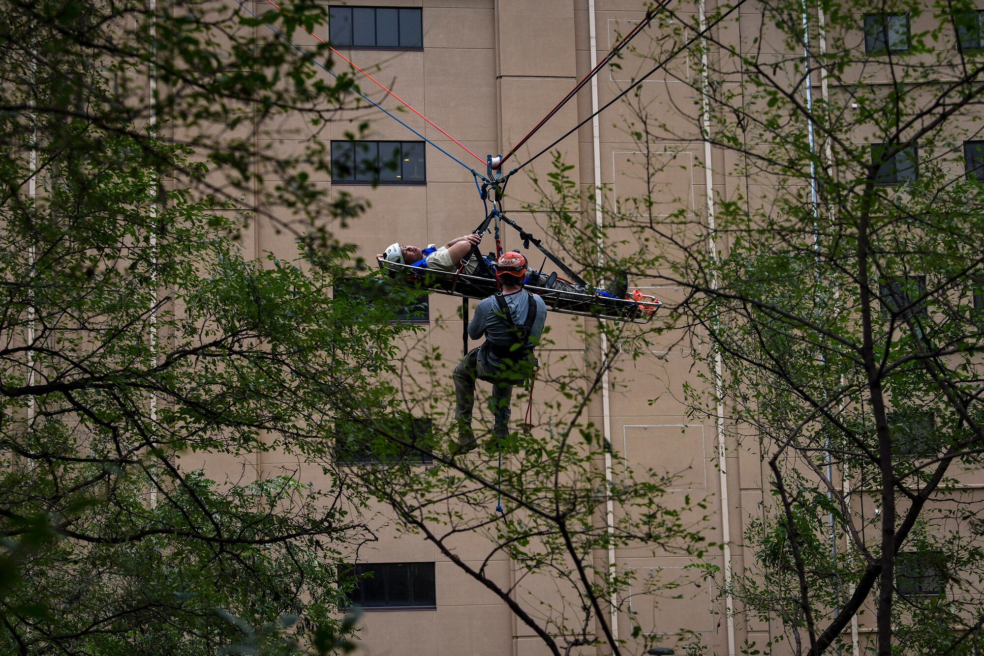 Airman 1st Class Sean Dearduff, 374th Civil Engineer Squadron firefighter, Yokota Air Base, Japan, waits to be hauled up an eight-story building to safely rescue a simulated victim as part of a Department of Defense Rescue Technician course, Sept. 9, 2019, at Osan Air Base, Republic of Korea. Instructors from Andersen Air Force Base, Guam’s 554th RED HORSE Squadron trained and tested 10 Pacific Air Forces firefighters from three bases on high-risk, elevated and confined space rescue tactics. (U.S. Air Force photo by Staff Sgt. Greg Nash)