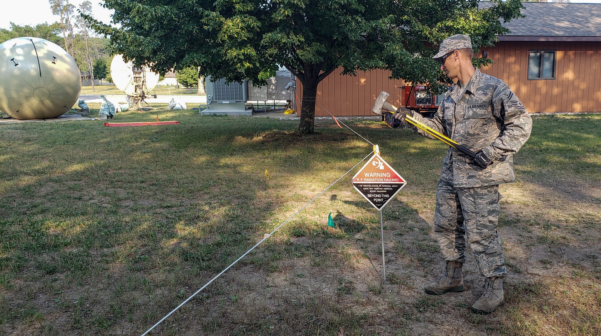 U.S. Air Force Senior Master Sgt. Roarke Singer, the radio frequency/cyber transport operations section chief for the 271st Combat Communications Squadron, Pennsylvania Air National Guard, marks an RF-radiation warning during Operation Northern Strike July 26, 2019, at the Alpena Combat Readiness Center in Michigan.