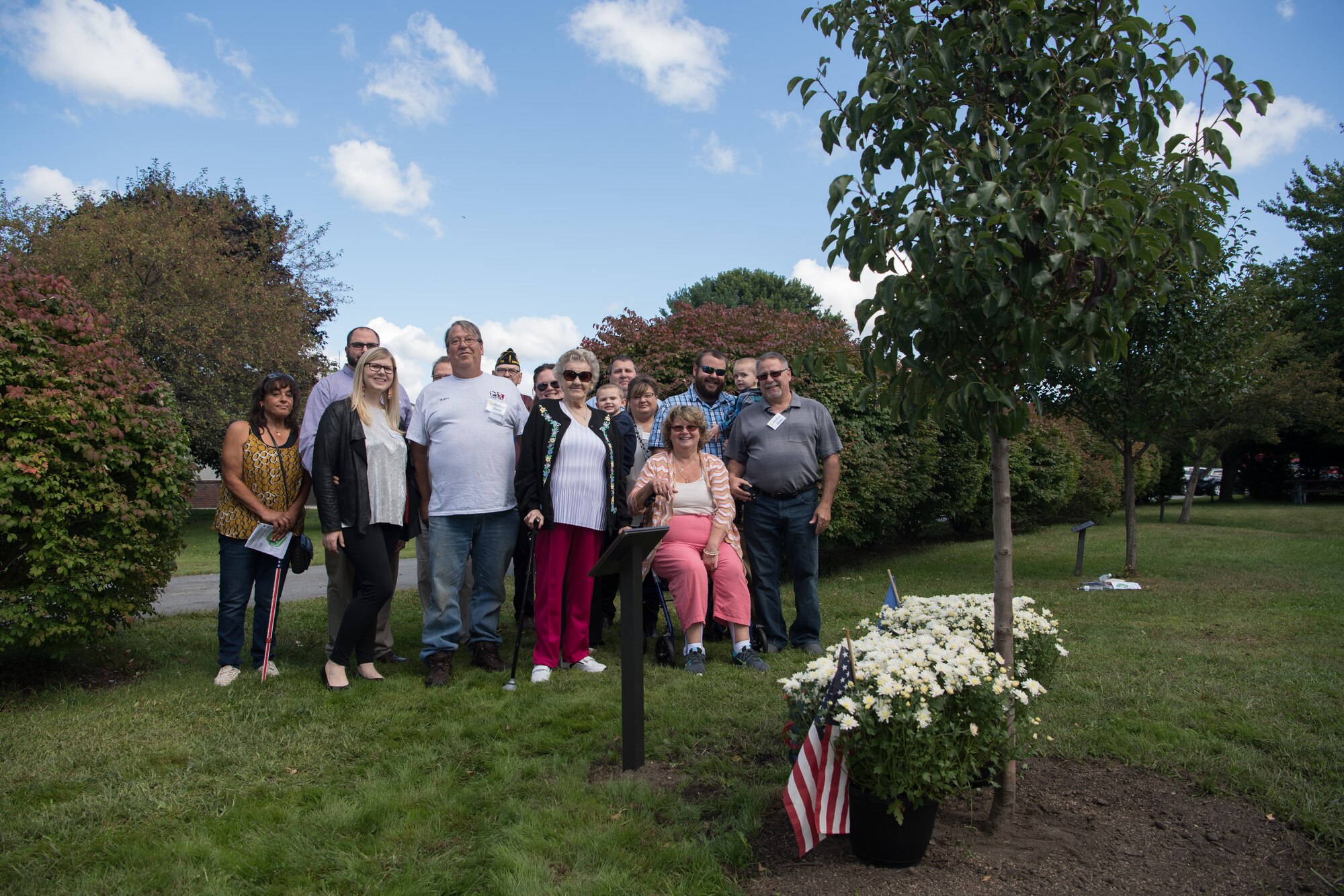Family members of Armand "Ollie" Ouellette pose for a photo in Hanscom Heroes Memorial Park at Hanscom Air Force Base, Mass. during a tree dedication ceremony in his name, Sept. 13, 2019. Memorial Park, which opened in 1991, recognizes deceased members of the Hanscom community who had made a significant impact at the base. (U.S. Air Force photo by Jerry Saslav)