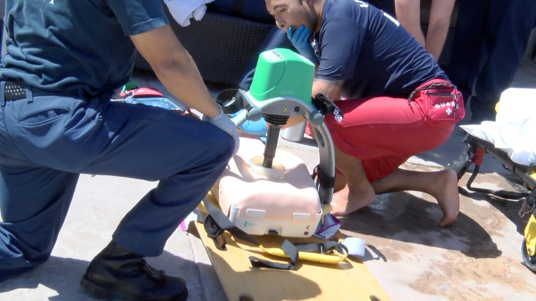 Francisco Cadillo, primary lifeguard, Oasis Pool, watches as an automatic chest compressor is attached to the rescue board containing an unresponsive drown victim and positioned over the chest before being turned on to deliver textbook perfect compressions, pausing long enough to allow a rescuer to deliver two breaths before resuming the process again. The ACC allows the proper rescue compressions to be administered in a moving ambulance so the paramedic can remain constrained in the seat for safety.
