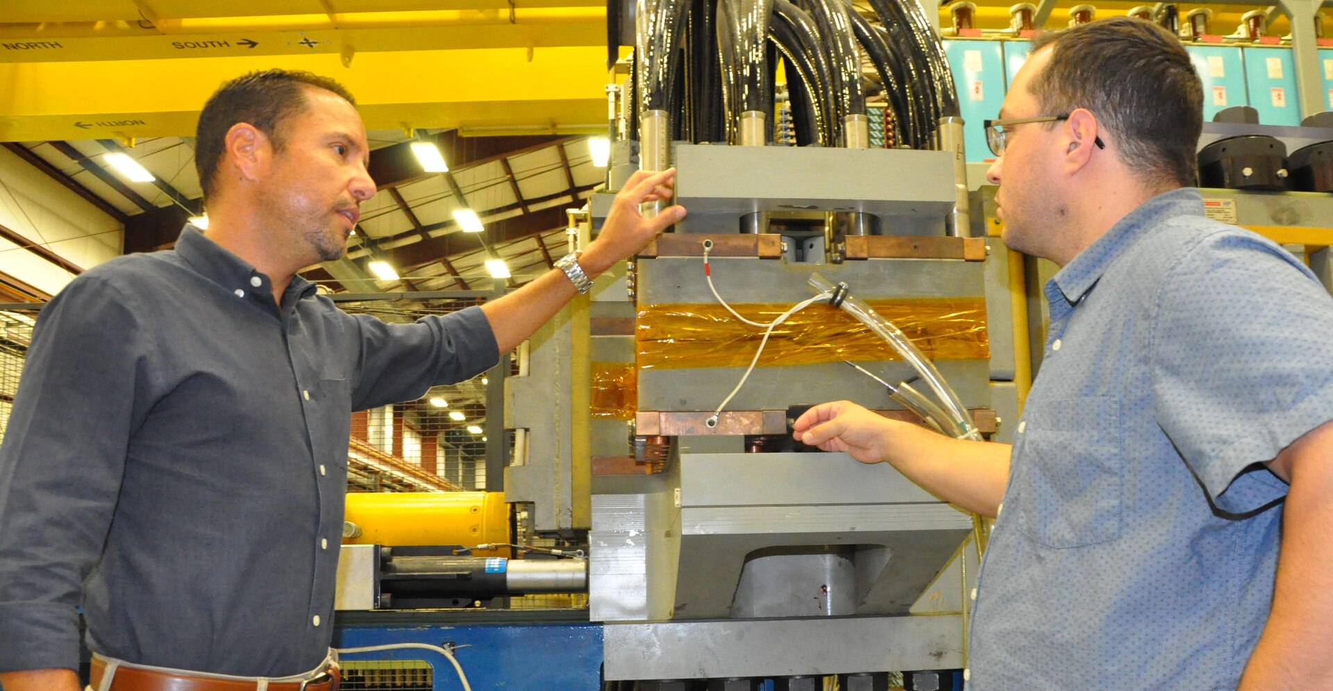 IMAGE: DAHLGREN, Va. (Sept. 5, 2019) - Moises Iglesias – lead systems engineer for the electromagnetic railgun weapon system at Naval Surface Warfare Center Dahlgren Division (NSWCDD) – discusses railgun design considerations with his colleague, Pierre Avila, NSWCDD computer scientist.  “A leader helps the organization, the team, and its members become famous - providing the tools, training, development, recognition and opportunities to deliver products that will help the organization and its members grow professionally and personally while establishing the organization’s National Subject Matter Expertise and Recognition,” said Iglesias, an avid runner and native of Carolina, Puerto Rico.