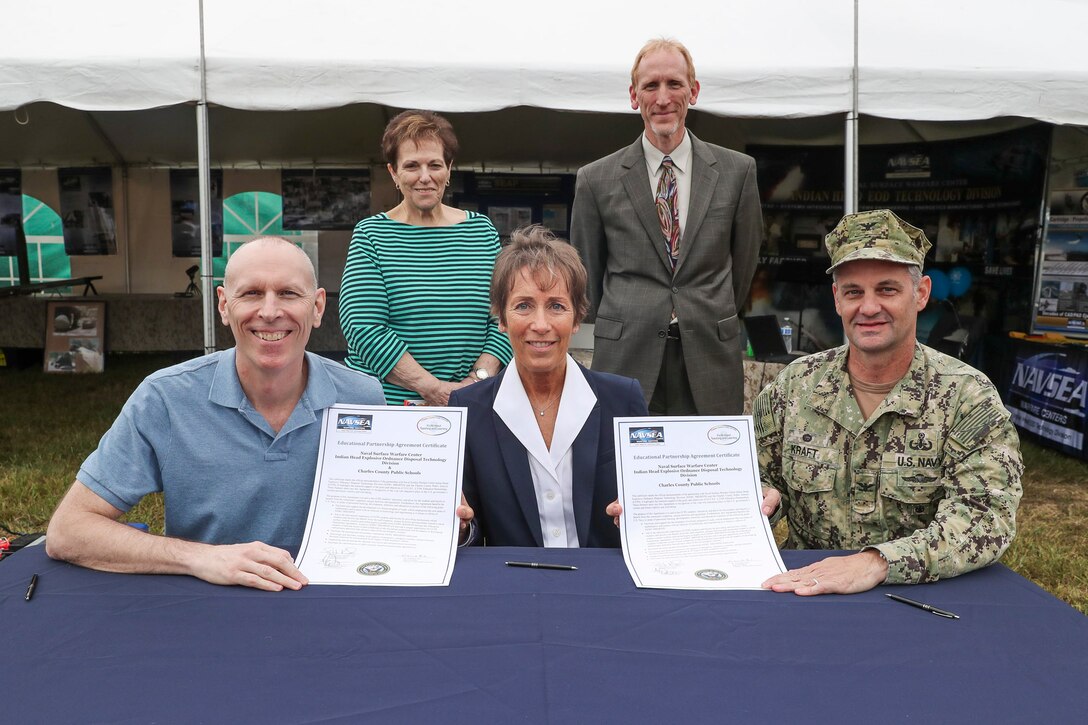Front, left to right: Naval Surface Warfare Center (NSWC) Indian Head Explosive Ordnance Disposal Technology Division Technical Director (IHEODTD) Ashley Johnson; Charles County Public School Superintendent Dr. Kim Hill; and NSWC IHEODTD Commanding Officer Capt. Scott Kraft sign an Educational Partnership Agreement between the two organizations during a ceremony at the Charles County Fair, Sept. 13.

Also pictured: Charles County Board of Education Chairman Virginia McGraw and board member Michael Lukas.