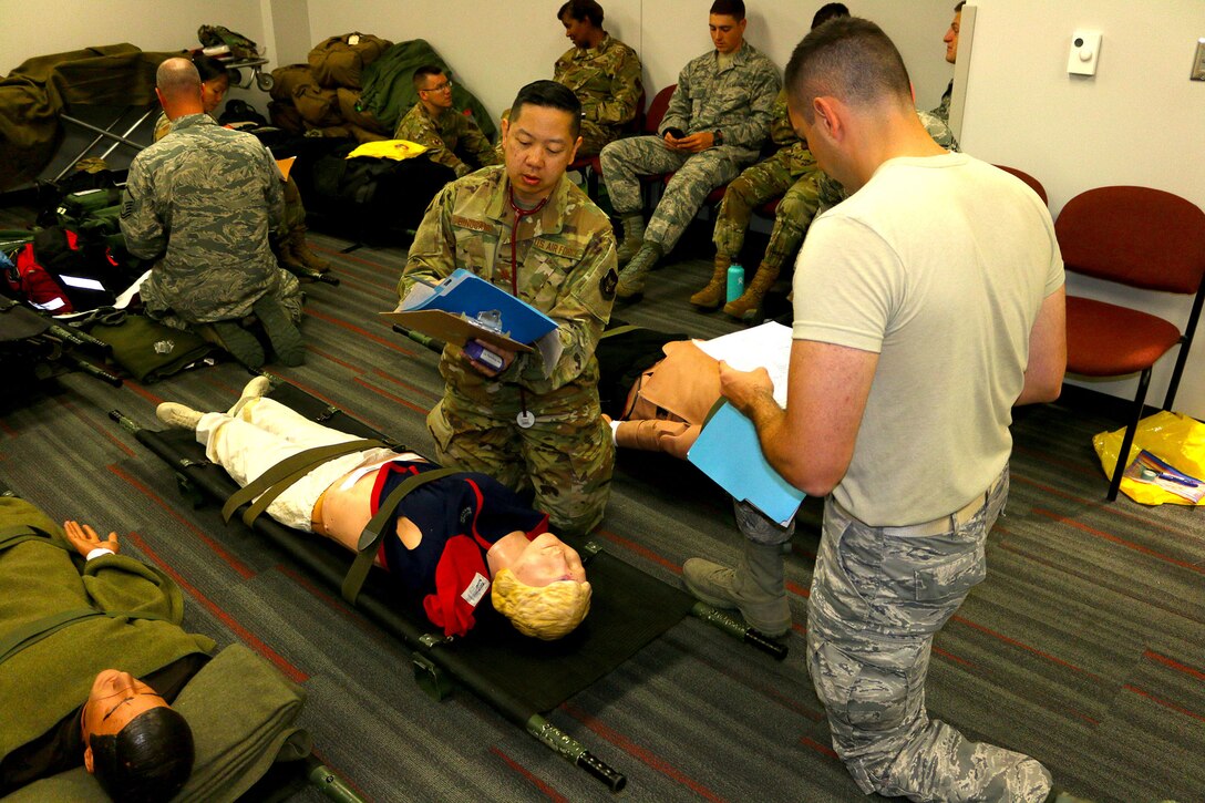 Maj. Alexander Bingcang, 445th Aeromedical Staging Squadron, diagnosis “patients” during a combined training event Aug. 3, 2019. Reserve Citizen Airmen from the ASTS, 445th Aeromedical Evacuation Squadron and 89th Airlift Squadron participated in a combined training effort during their August UTA weekend.