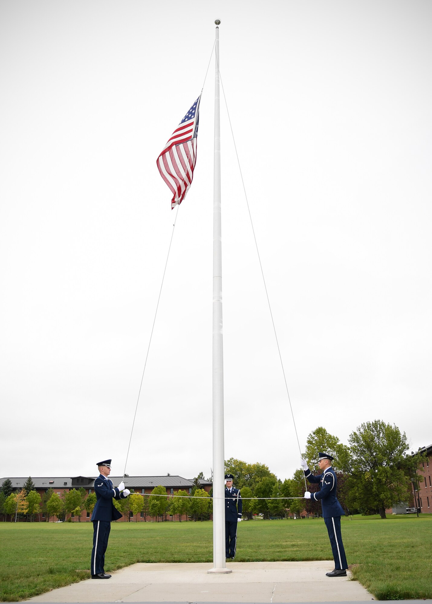 Grand Forks Air Force Base Honor Guardsmen perform retreat during a memorial ceremony Sept.11, 2019, on Grand Forks Air Force Base, North Dakota. Airmen and community members attended the ceremony, which honored those who died from the attacks on 9/11. (U.S. Air Force photo by Senior Airman Elora J. Martinez)