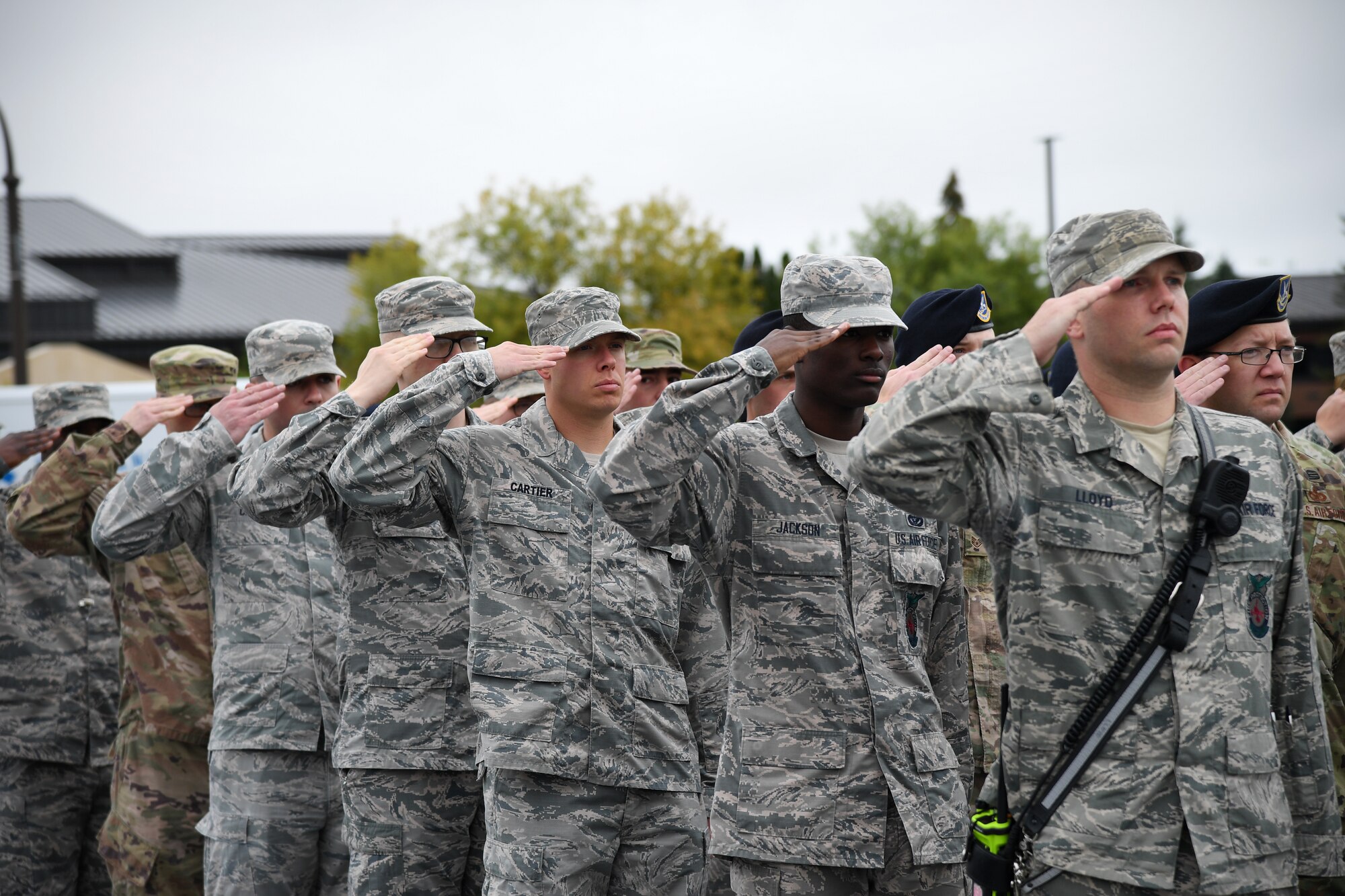 Members of the 319th Reconnaissance Wing salute the flag during a memorial ceremony Sept. 11, 2019, on Grand Forks Air Force Base, North Dakota. The flag was lowered and folded by Grand Forks AFB Honor Guard for retreat as part of the ceremony to commemorate the lives lost in the 9/11 attacks. (U.S Air Force photo by Senior Airman Elora J. Martinez)