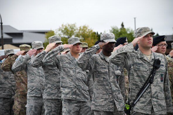 Members of the 319th Reconnaissance Wing salute the flag during a memorial ceremony Sept. 11, 2019, on Grand Forks Air Force Base, North Dakota. The flag was lowered and folded by Grand Forks AFB Honor Guard for retreat as part of the ceremony to commemorate the lives lost in the 9/11 attacks. (U.S Air Force photo by Senior Airman Elora J. Martinez)
