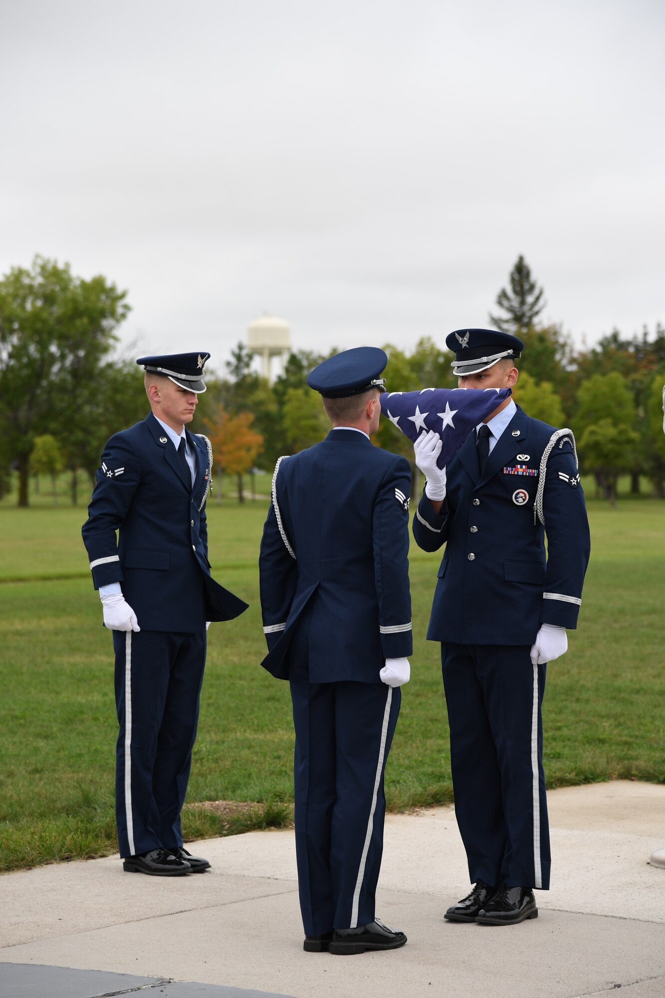 Grand Forks Air Force Base Honor Guardsmen honor the flag as they perform retreat during a memorial ceremony Sept. 11, 2019, on Grand Forks Air Force Base, North Dakota. The ceremony marked a day of remembrance for the immense loss America felt following the attacks of 9/11. Airmen also honored the lives of the attack victims with a commemorative stair climb in the air traffic control tower on base; completing 14 trips up the tower to equate the World Trade Center’s 110 stories. (U.S. Air Force photo by Senior Airman Elora J. Martinez)