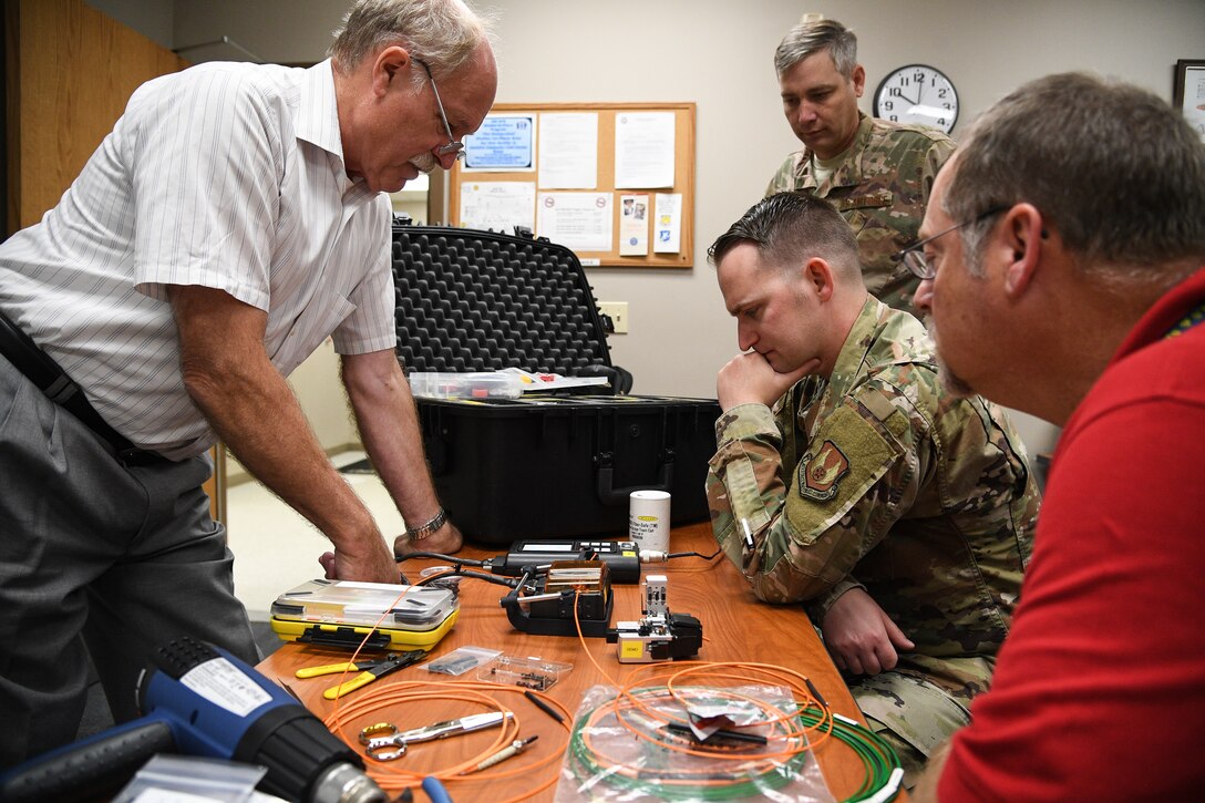 Laurence Wesson, left, trains Tech. Sgt. Kenan Harvey on a fusion splicer for fiber optic cable repair at Hill Air Force Base, Utah, Sept. 10, 2019.