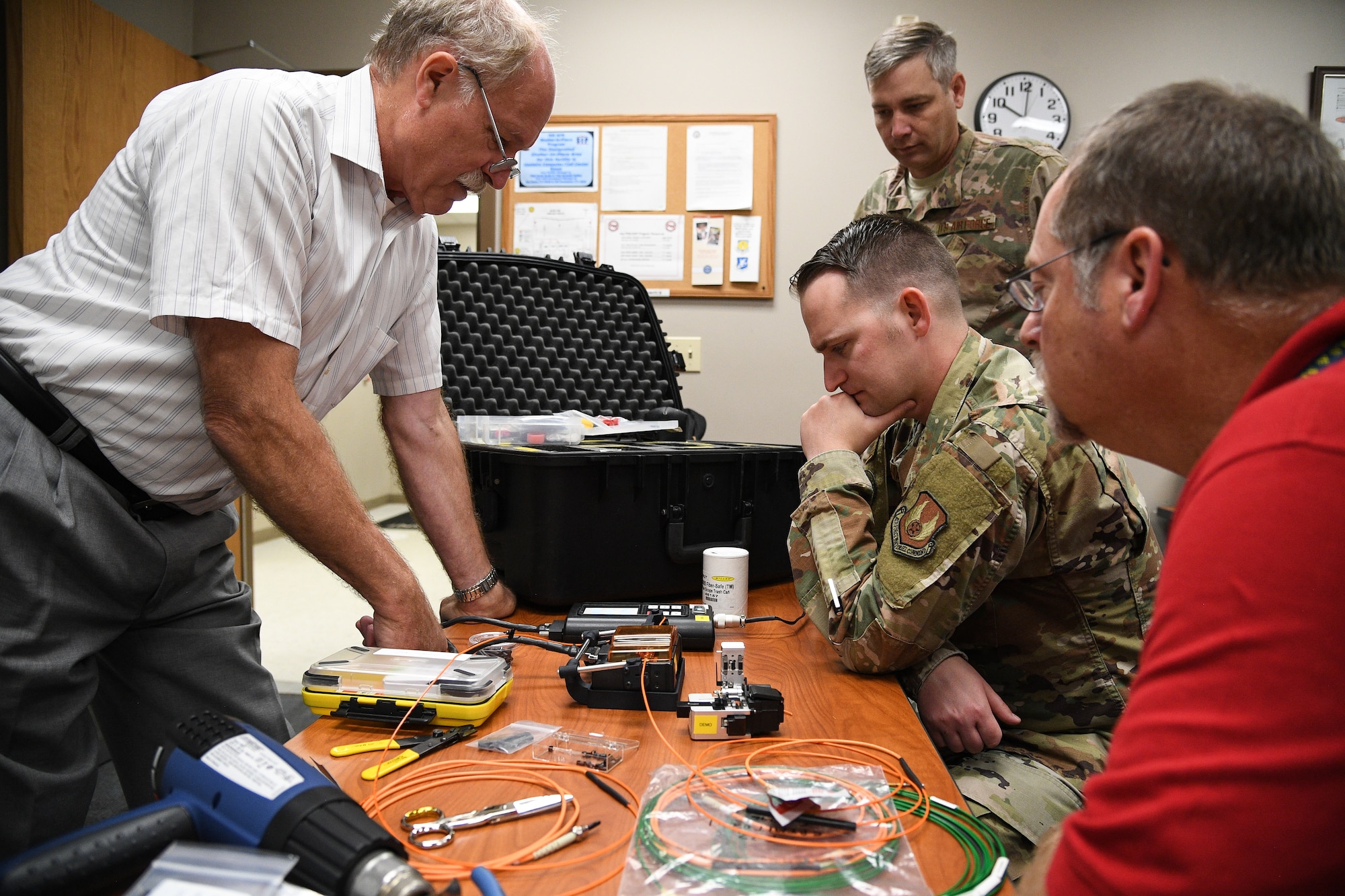 Laurence Wesson, left, trains Tech. Sgt. Kenan Harvey on a fusion splicer for fiber optic cable repair at Hill Air Force Base, Utah, Sept. 10, 2019.