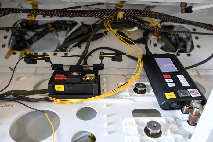 A repaired F-35A Lightning II fiber optic cable is held by a small, portable fusion splicer during a field test at Hill Air Force Base, Utah, Sept. 12, 2019.