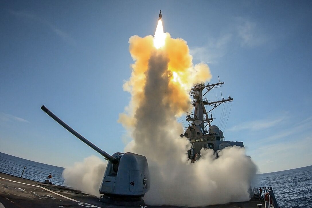 A missile launches from a military ship.