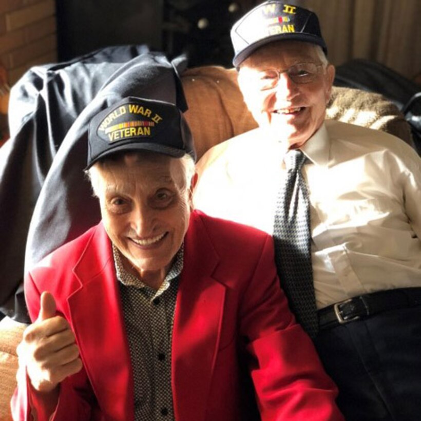 Photograph of two elderly men wearing caps with the words “World War II Veteran.”