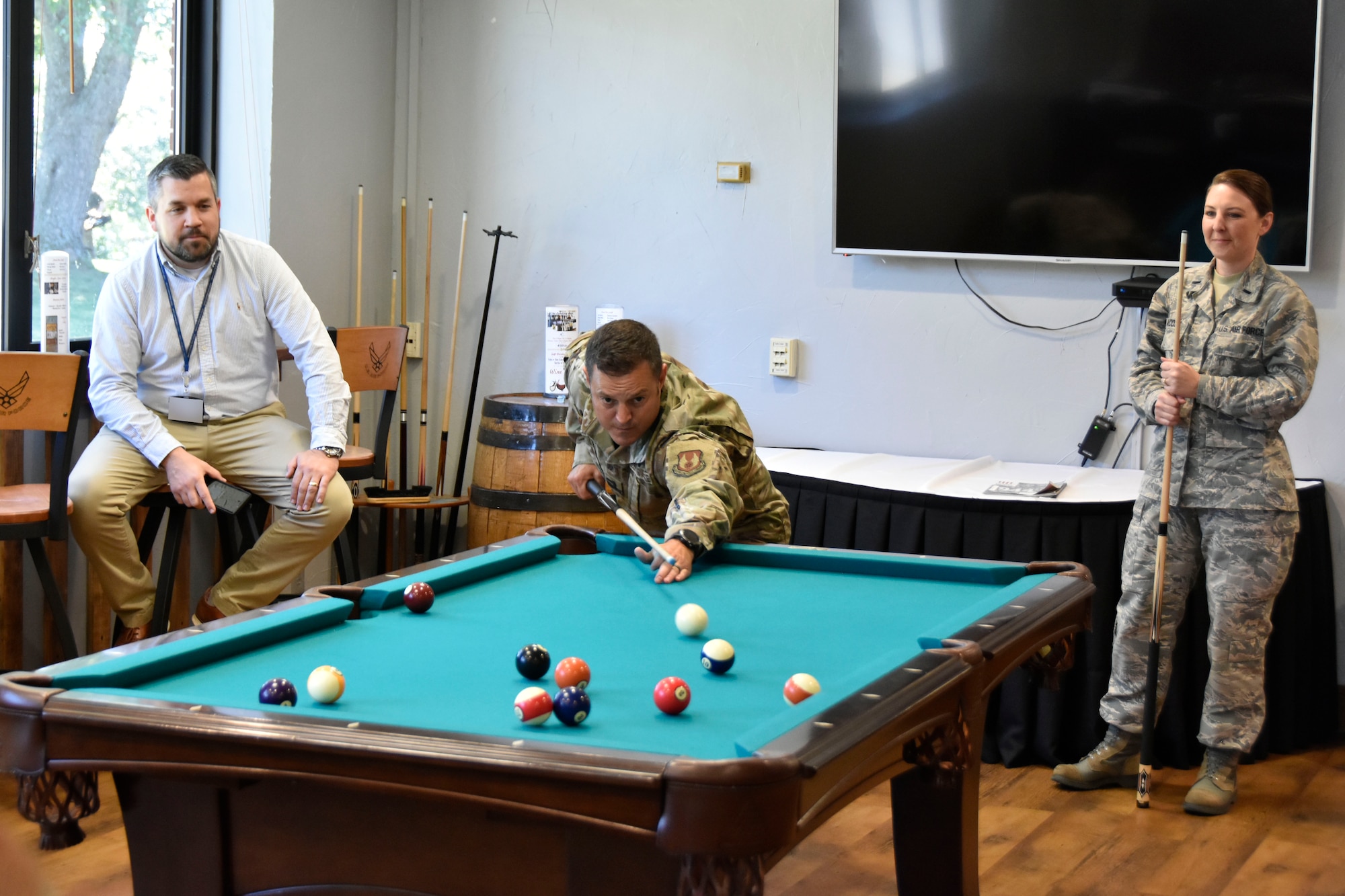 Nathan Harrison, left, watches as 1st Lt. Brad Landry, center, and 1st Lt. Karlie Madden play a game of pool in the Arnold Lakeside Center during the Aug. 29 “Let’s Connect” event. “Let’s Connect” was a portion of the Resilience Tactical Pause at Arnold. In early August, Air Force Chief of Staff David Goldfein ordered all Air Force units to stand down for one day to focus on suicide prevention. The event at Arnold was held to comply with this directive and boost interpersonal connection among base personnel. (U.S. Air Force photo by Bradley Hicks) (This image was altered by obscuring badges for security purposes.)