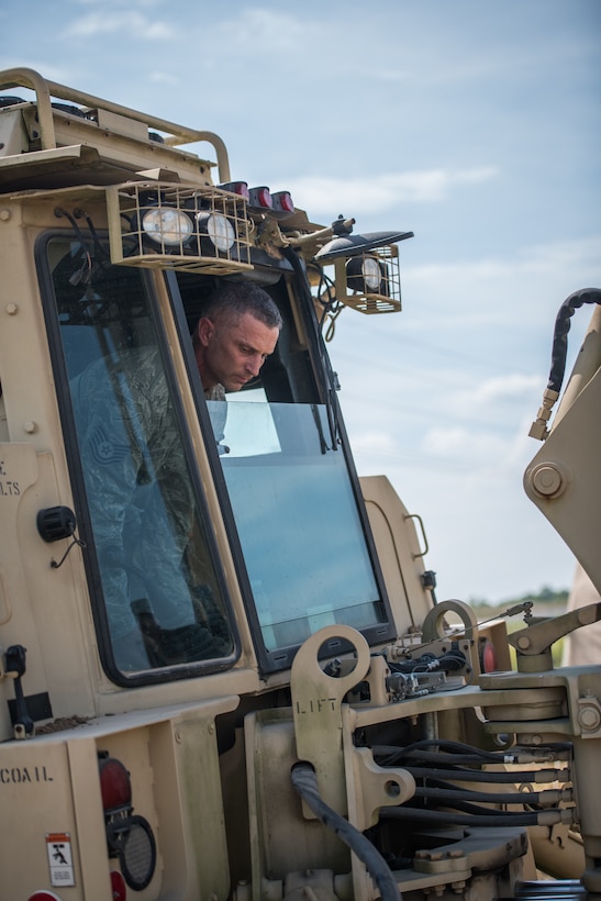 Tech. Sgt. Casey Goodaker,  932nd Civil Engineer Squadron technician, takes a closer look while positioning the backhoe bucket during field training, Sept. 10, 2019 at the Sparta National Guard training area, Sparta, Illinois. The 932nd CES spent two days at the training facility using the space for heavy equipment training, something they are not able to perform at Scott Air Force Base during unit training assemblies.  (U.S. Air Force photo by Master Sgt. Christopher Parr)