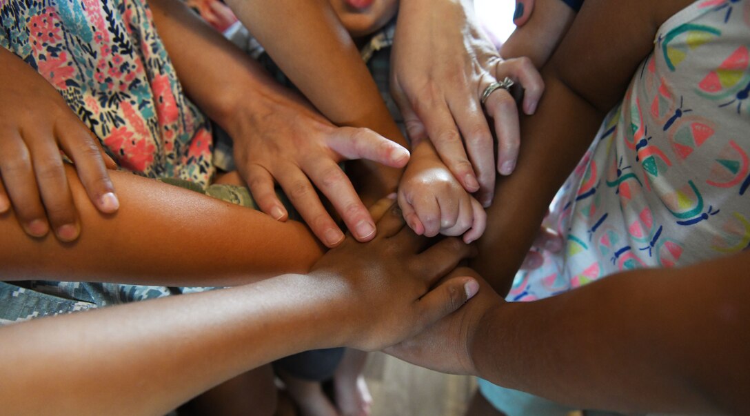 Foster children stand in a circle and put their hands in the center at Ellsworth Air Force Base, S.D., Aug. 2, 2019. Staff Sgt. Jordan Combs, a 28th Bomb Wing administration executive support specialist, and his wife, Mallory, are opening up a ranch for foster children where they will have multiple activities planned to allow kids to just be kids in a family-friendly and nurturing environment. (U.S. Air Force photo by Senior Airman Thomas Karol)