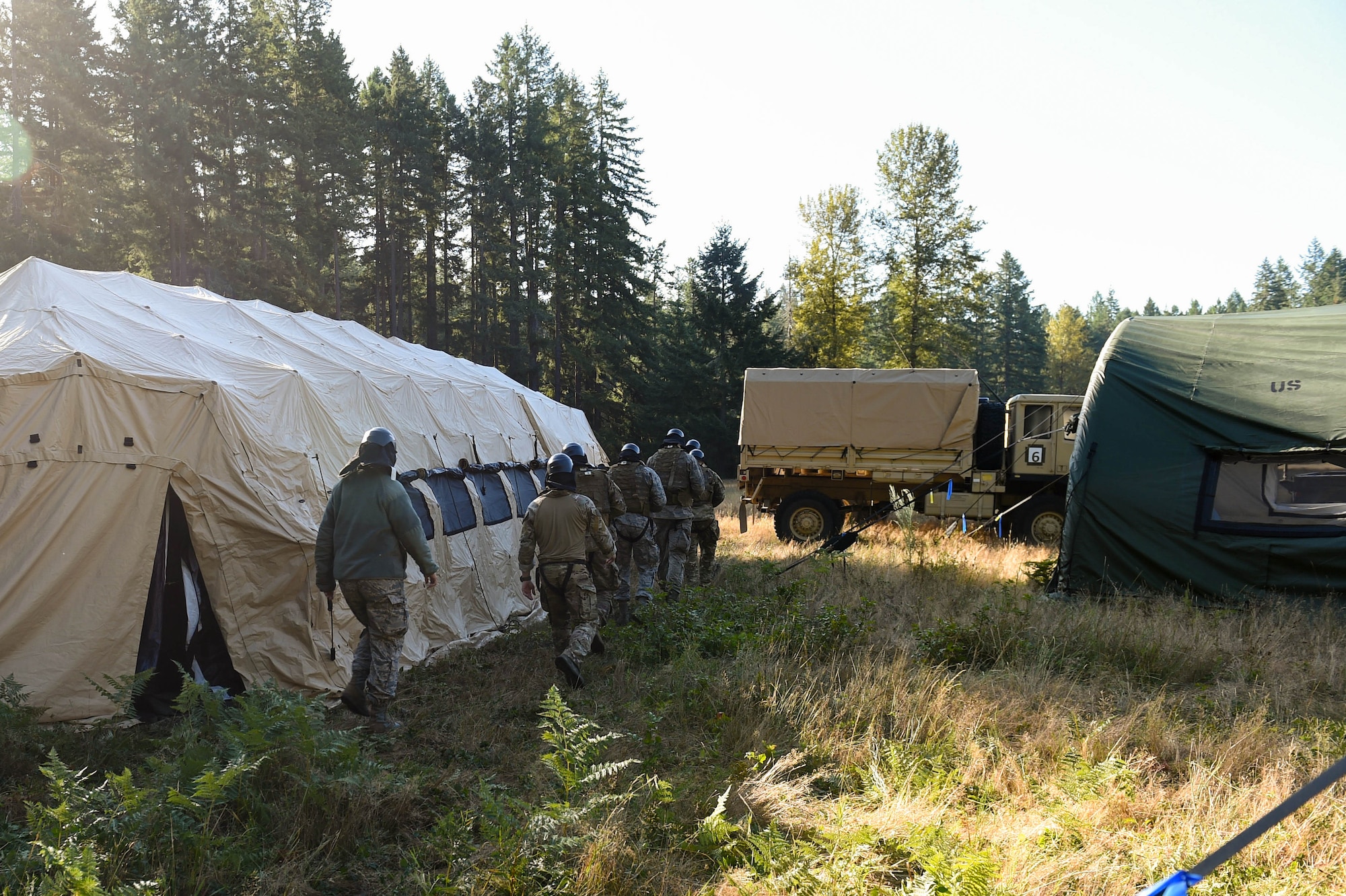 A team of five tactical air control party (TACP) officer candidates move towards a mock-deployment tactical village to complete a combat leadership objective challenge as part of TOPT selection course phase II on Joint Base Lewis-McChord, Wash., Aug. 27, 2019. TOPT is the selection process for officers who want to join the TACP career field in the U.S. Air Force.