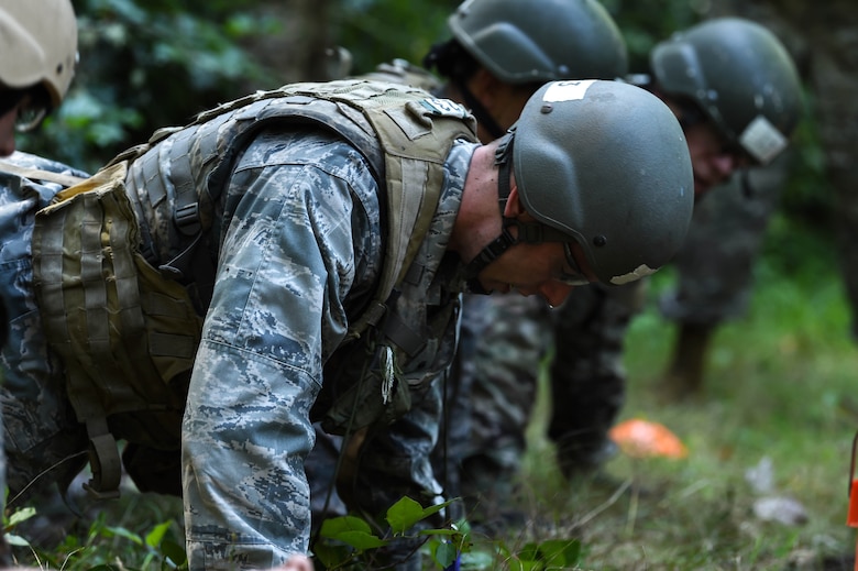 A team of tactical air control party (TACP) officer candidates, participating in a land navigation exercise during the TOPT selection course phase II, perform push-ups as an added element of stress while working on a team problem-solving activity Joint Base Lewis-McChord, Wash., Aug. 27, 2019. Candidates were evaluated on their performance under high levels of stress by experienced TACP officer and enlisted cadre, as well as Air Force psychologists throughout the week-long selection process.